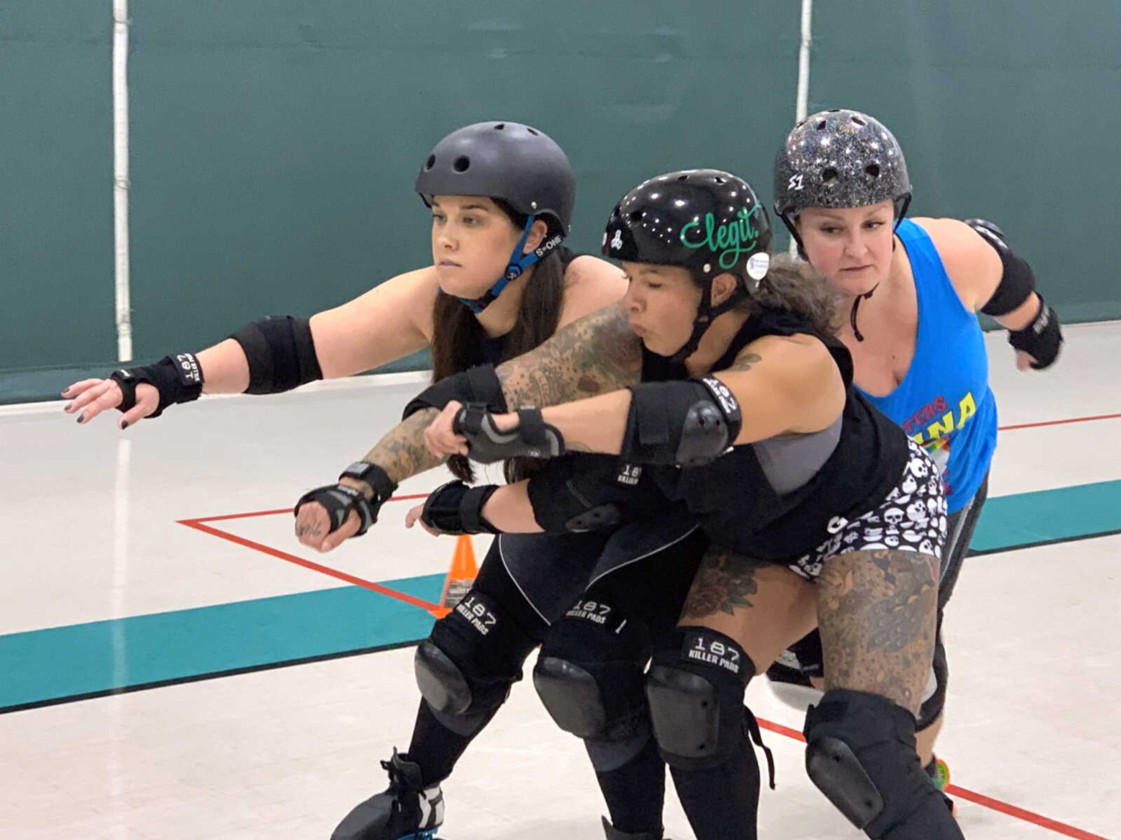 Bri Dewitt, left, and Emily Kirn, right, practice blocking Kristin Rickman from passing them, in a move called "seaming," recently at the Osage Centre gym in Cape Girardeau.