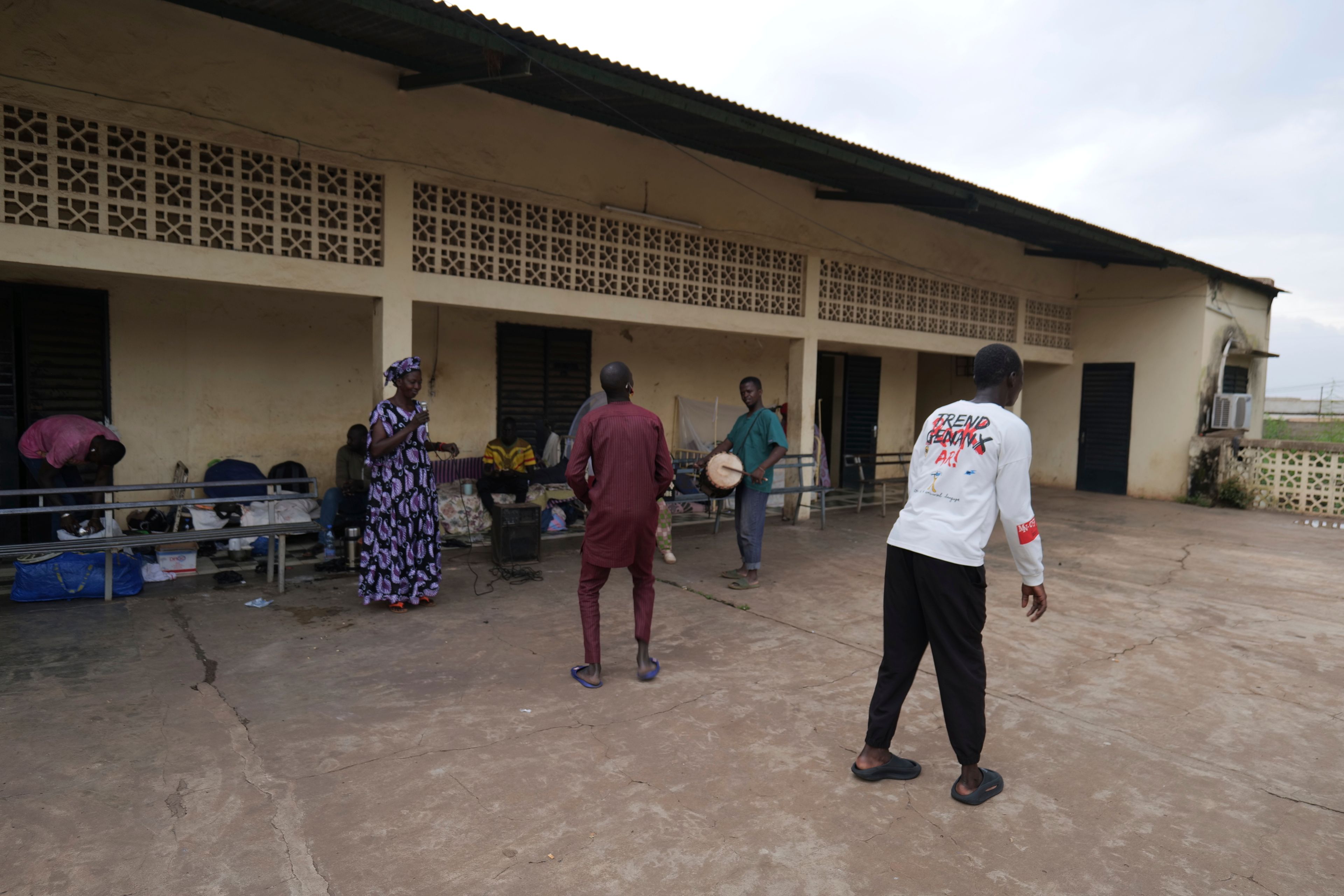 Mamadou Diarra, right, dances with other patients at Bamako's Point G hospital psychiatric ward in the hospital's courtyard in Bamako, Mali, Friday, Sept. 20, 2024. (AP Photo/Moustapha Diallo)