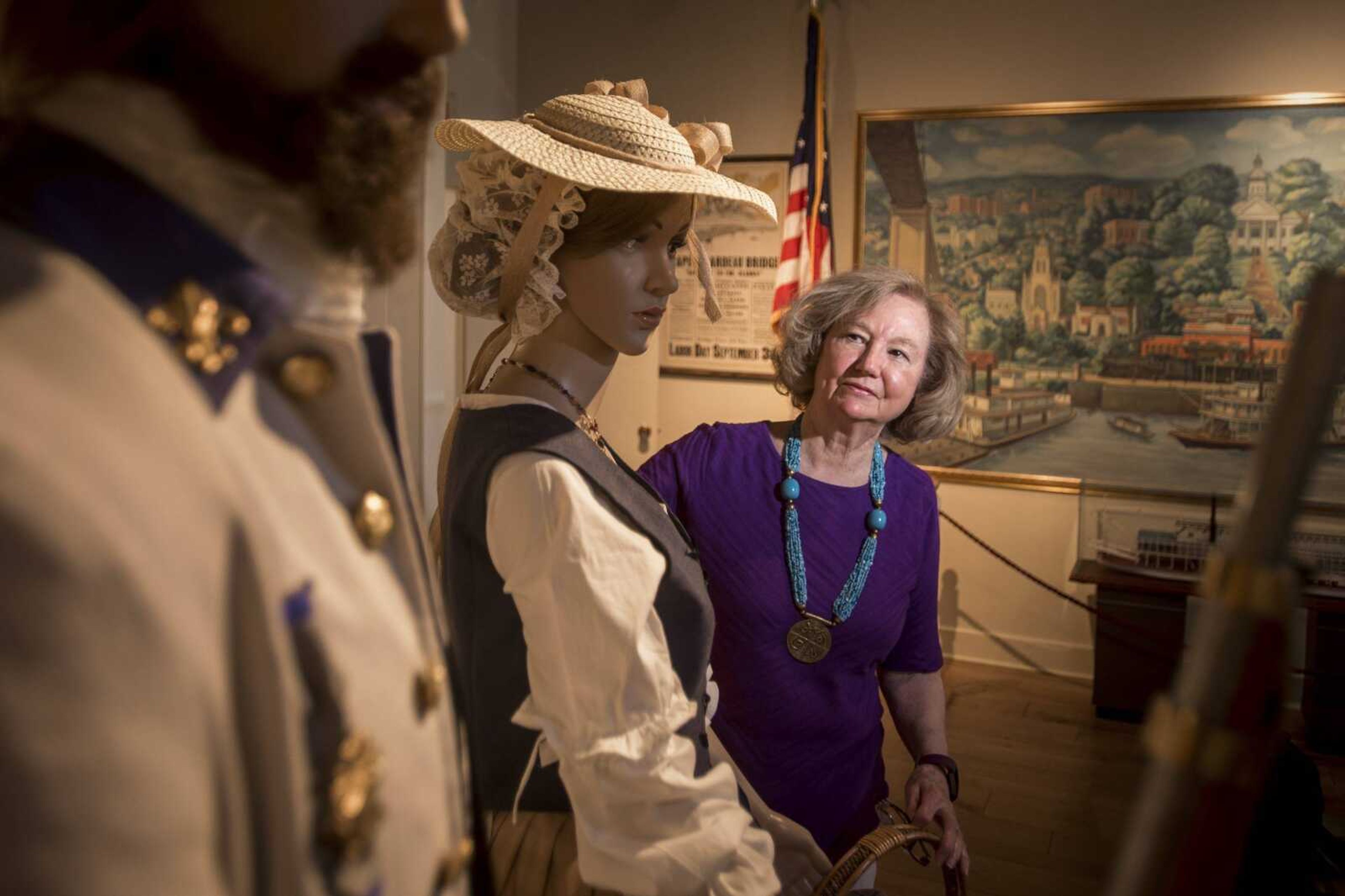 Charlotte Slinkard, who is responsible for making the costumes for figures at the Cape Girardeau River Heritage Museum, poses for a portrait with her creations May 24 at the museum in Cape Girardeau.