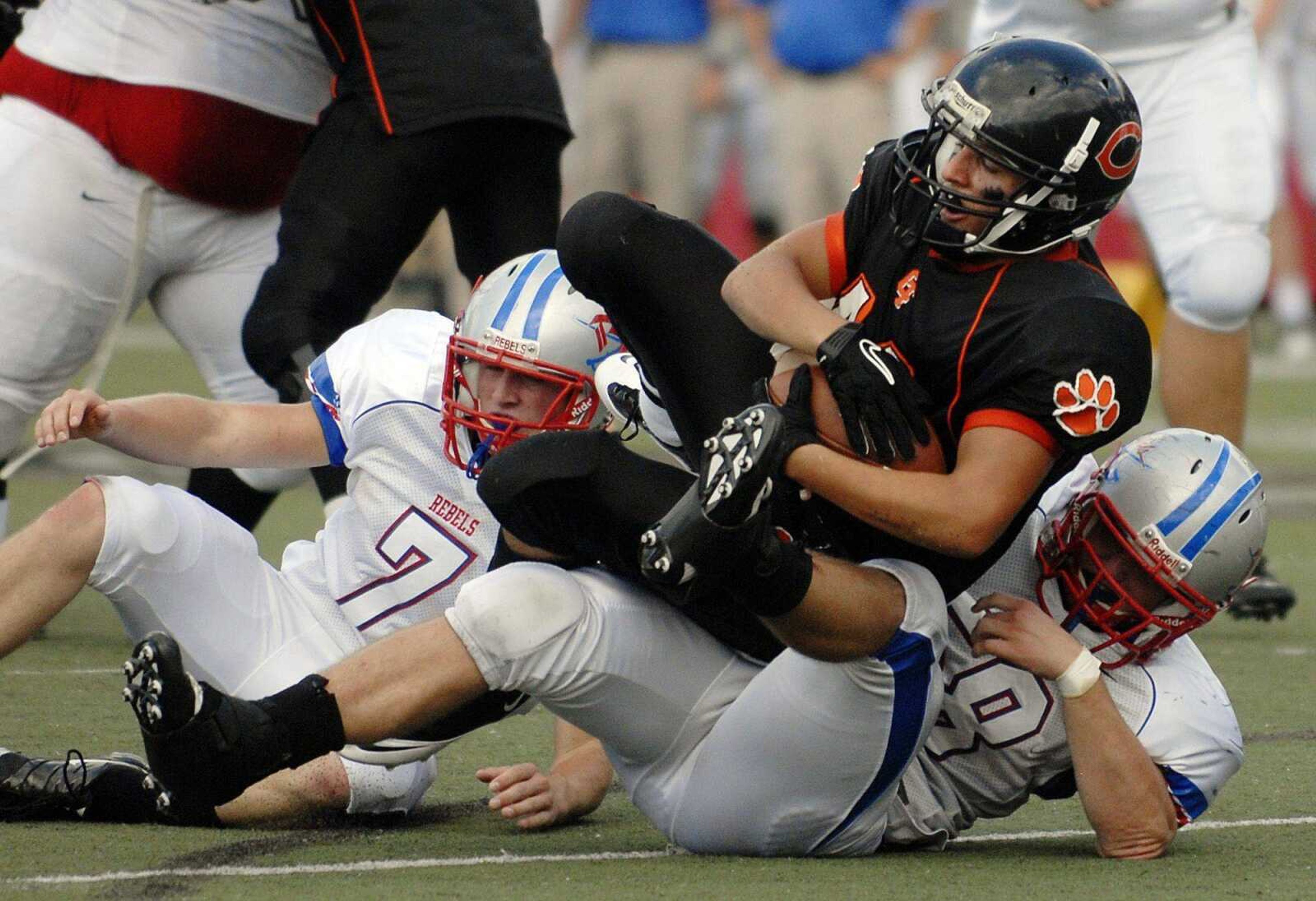 Obion County defenders Trent Mann, left, and Josh Quinton tackle Central senior Michael Reeder during Saturday's game at Houck Stadium.