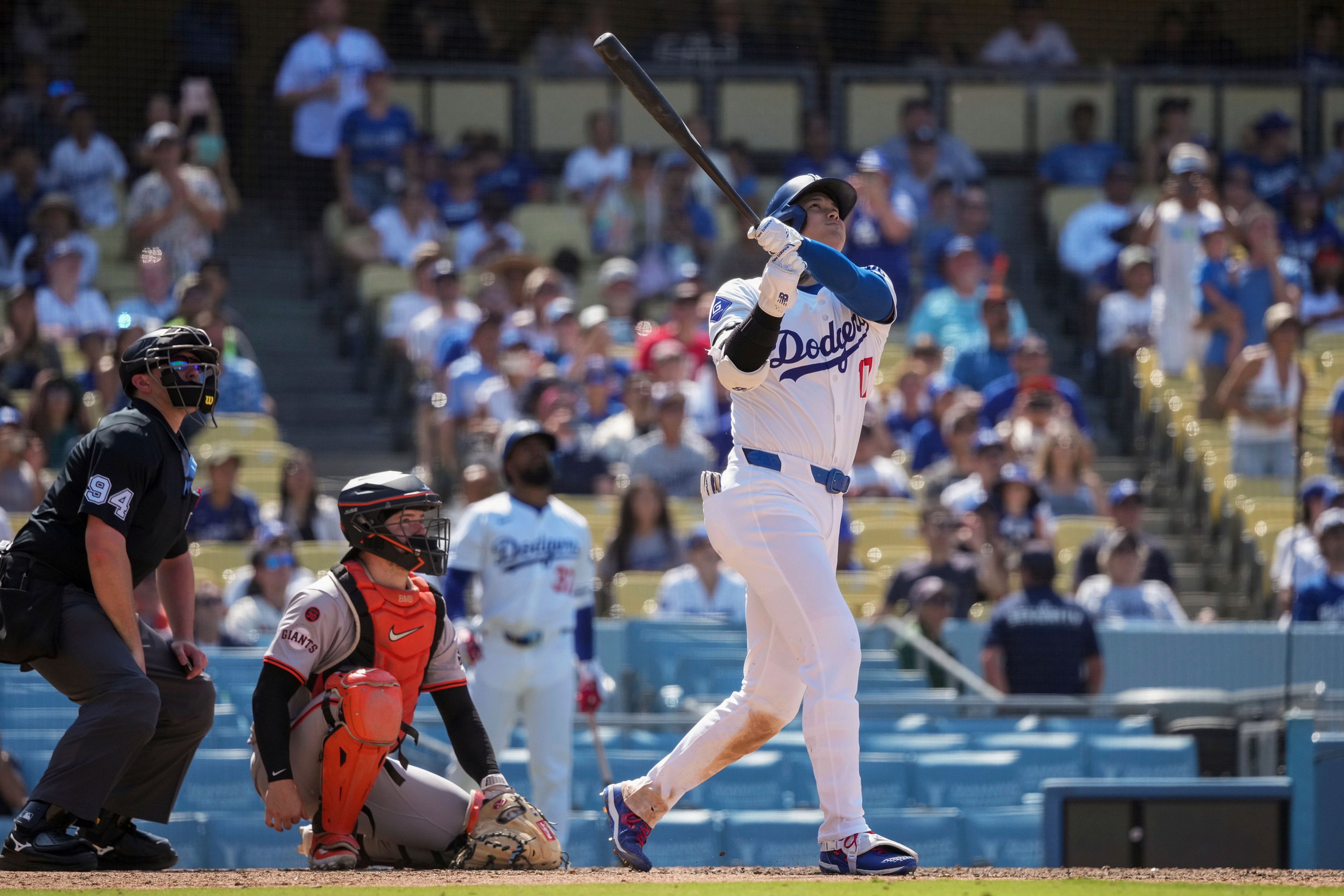 Los Angeles Dodgers designated hitter Shohei Ohtani, right, hits a home run during the eighth inning of a baseball game against the San Francisco Giants in Los Angeles, Thursday, July 25, 2024. (AP Photo/Eric Thayer)