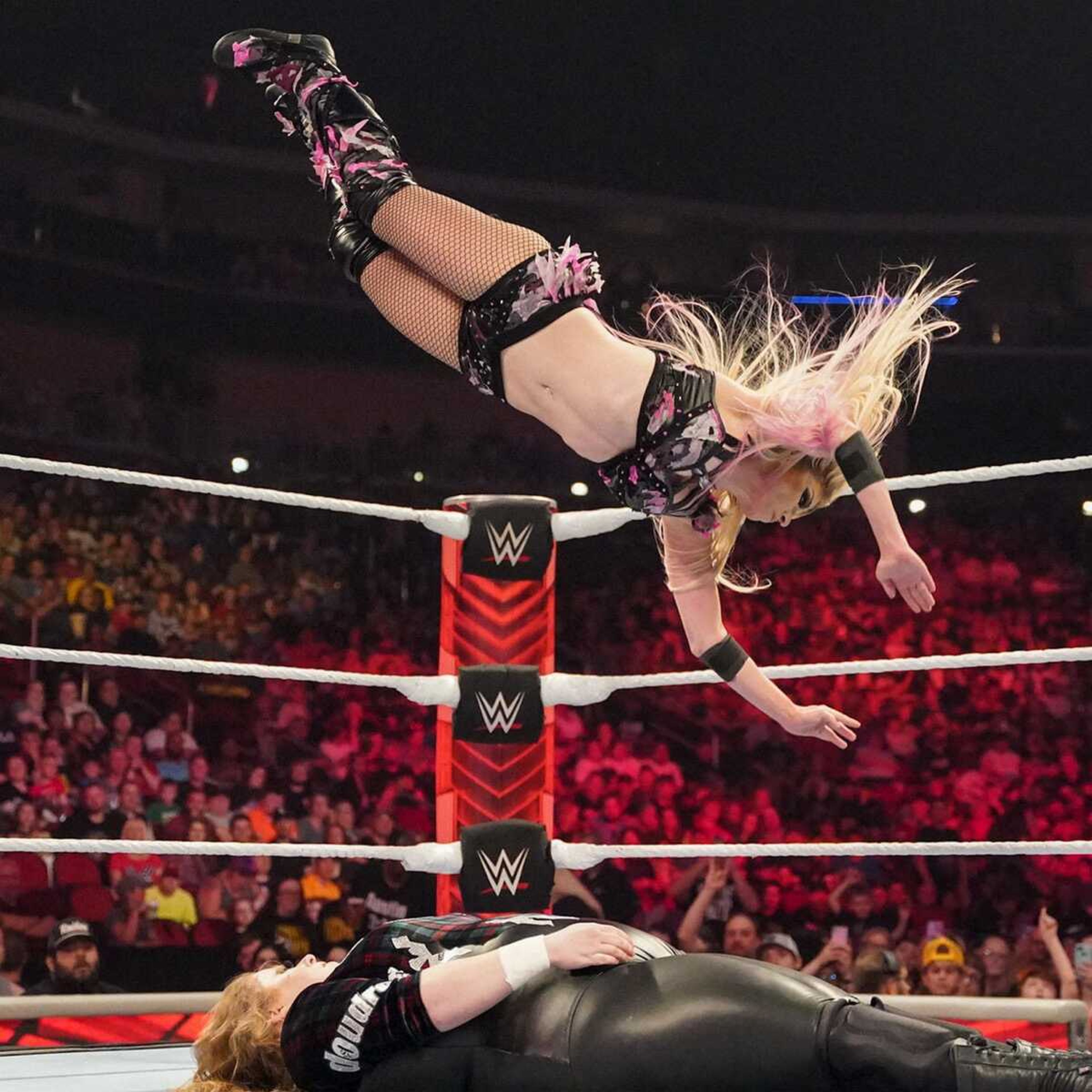 Alexa Bliss performs an aerial stunt during a match.