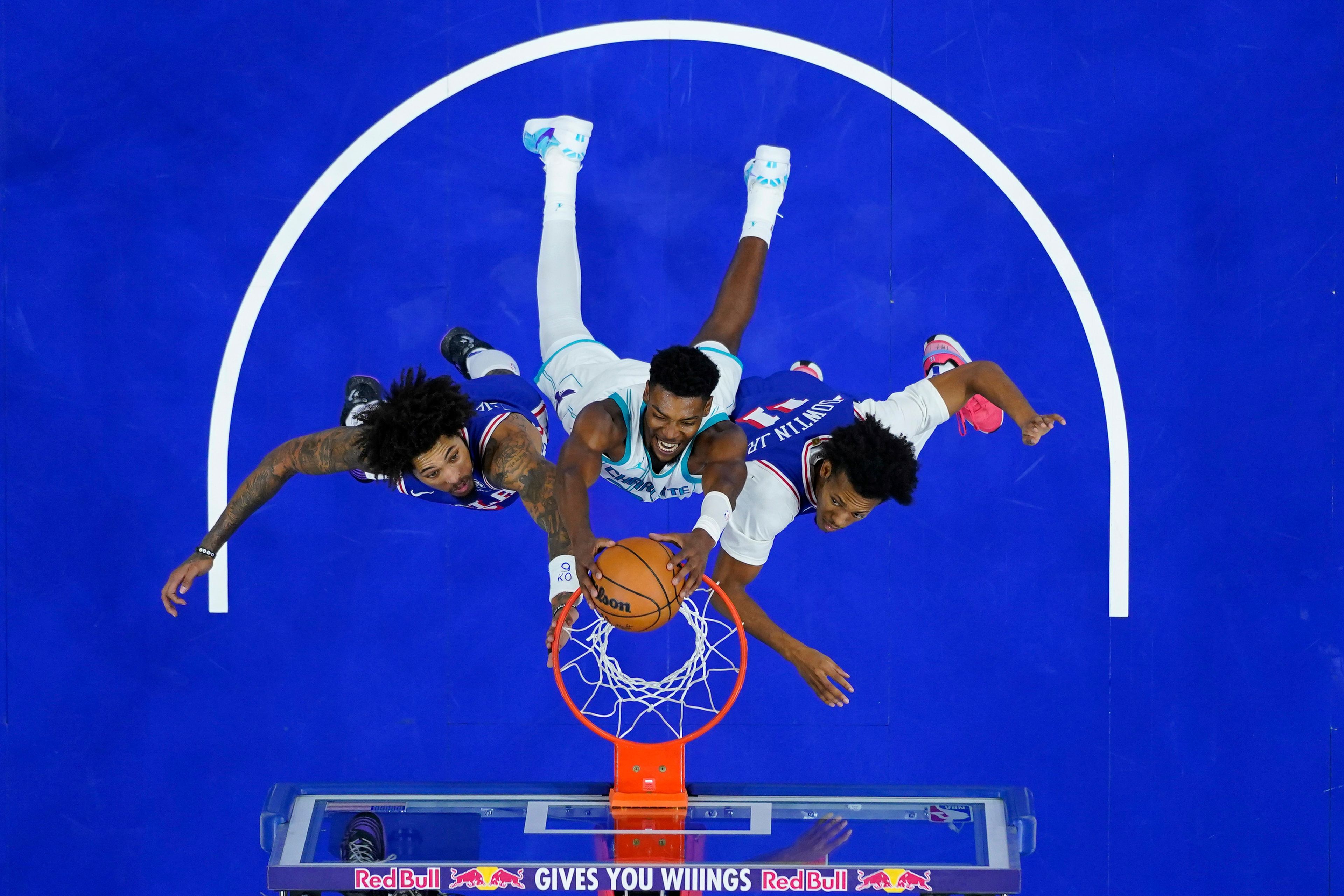 Charlotte Hornets' Brandon Miller, center, dunks between Philadelphia 76ers' Kelly Oubre Jr., left, and Jeff Dowtin Jr. during the second half of an NBA basketball game, Sunday, Nov. 10, 2024, in Philadelphia. (AP Photo/Matt Slocum)