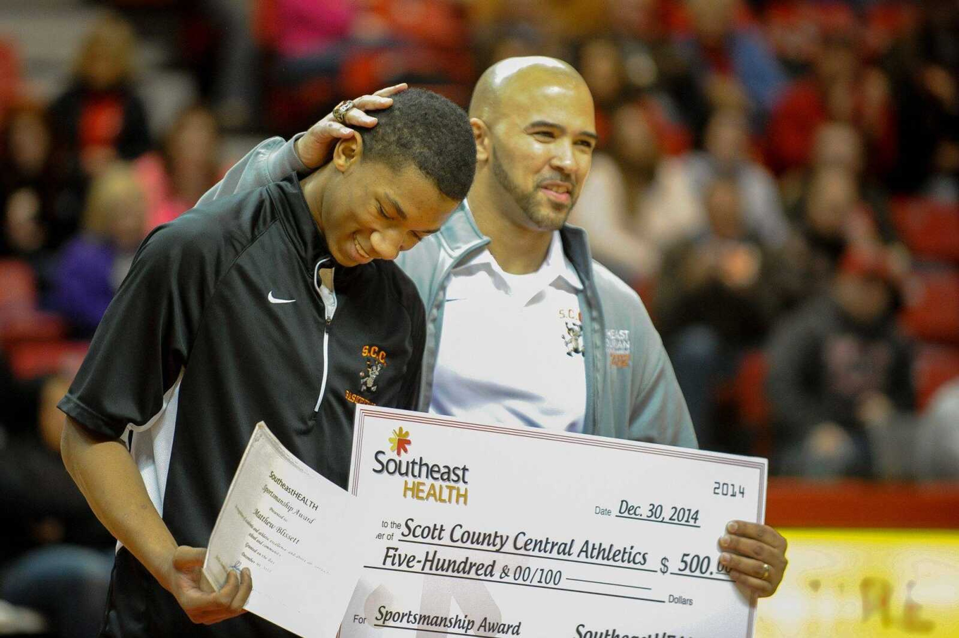 Scott County Central coach Frank Staple congratulates Matt Blissett after being awarded the sportsmanship award at the Southeast Missourian Christmas Tournament at the Show Me Center Tuesday, Dec. 30, 2014 (Glenn Landberg)