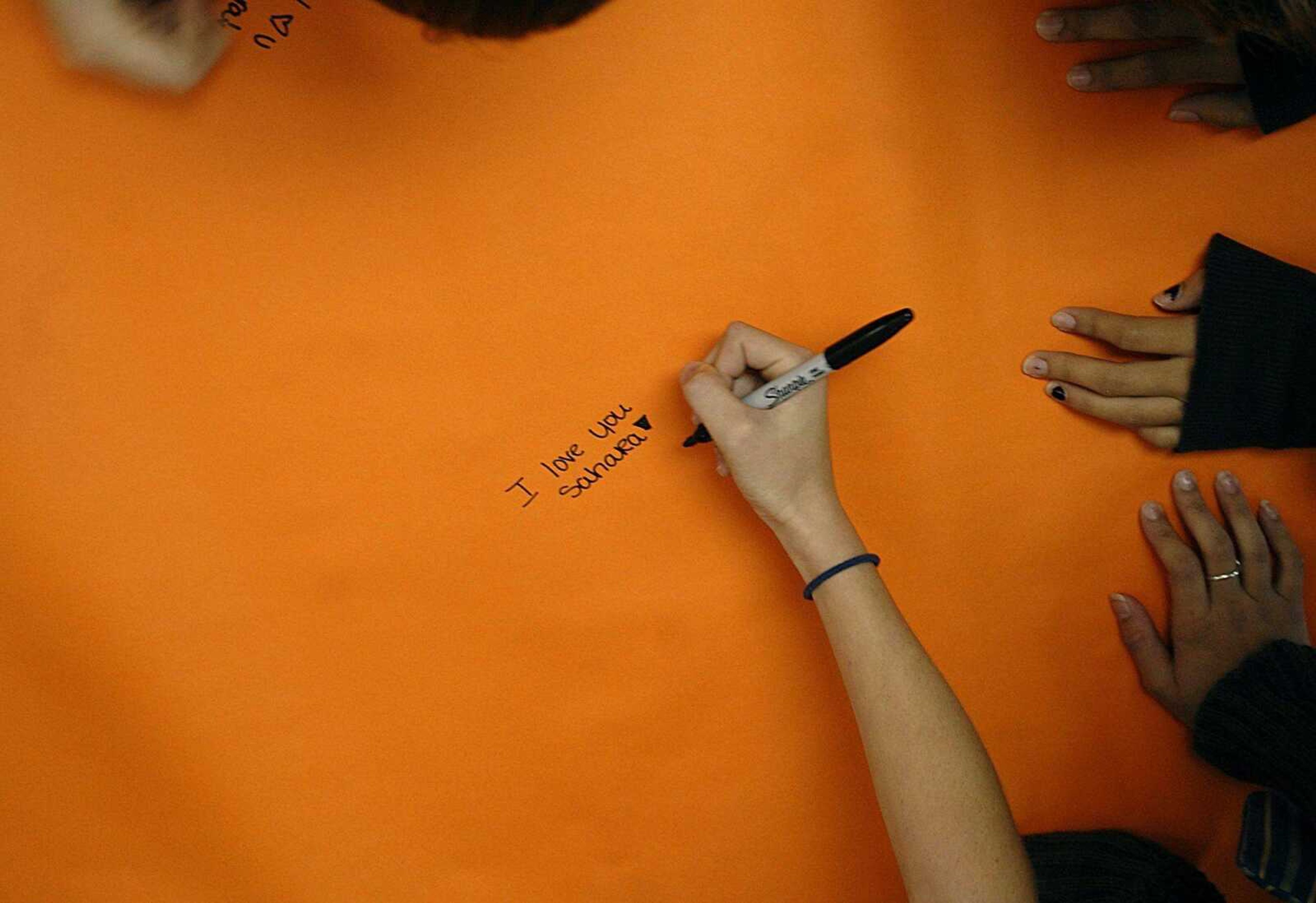 One of the first students to sign the banner puts an exclamation mark after her message for Sahara Aldridge, who lost her battle with cancer Monday night. Students at Central Junior High filled the banner with well wishes on Tuesday afternoon. (Aaron Eisenhauer)