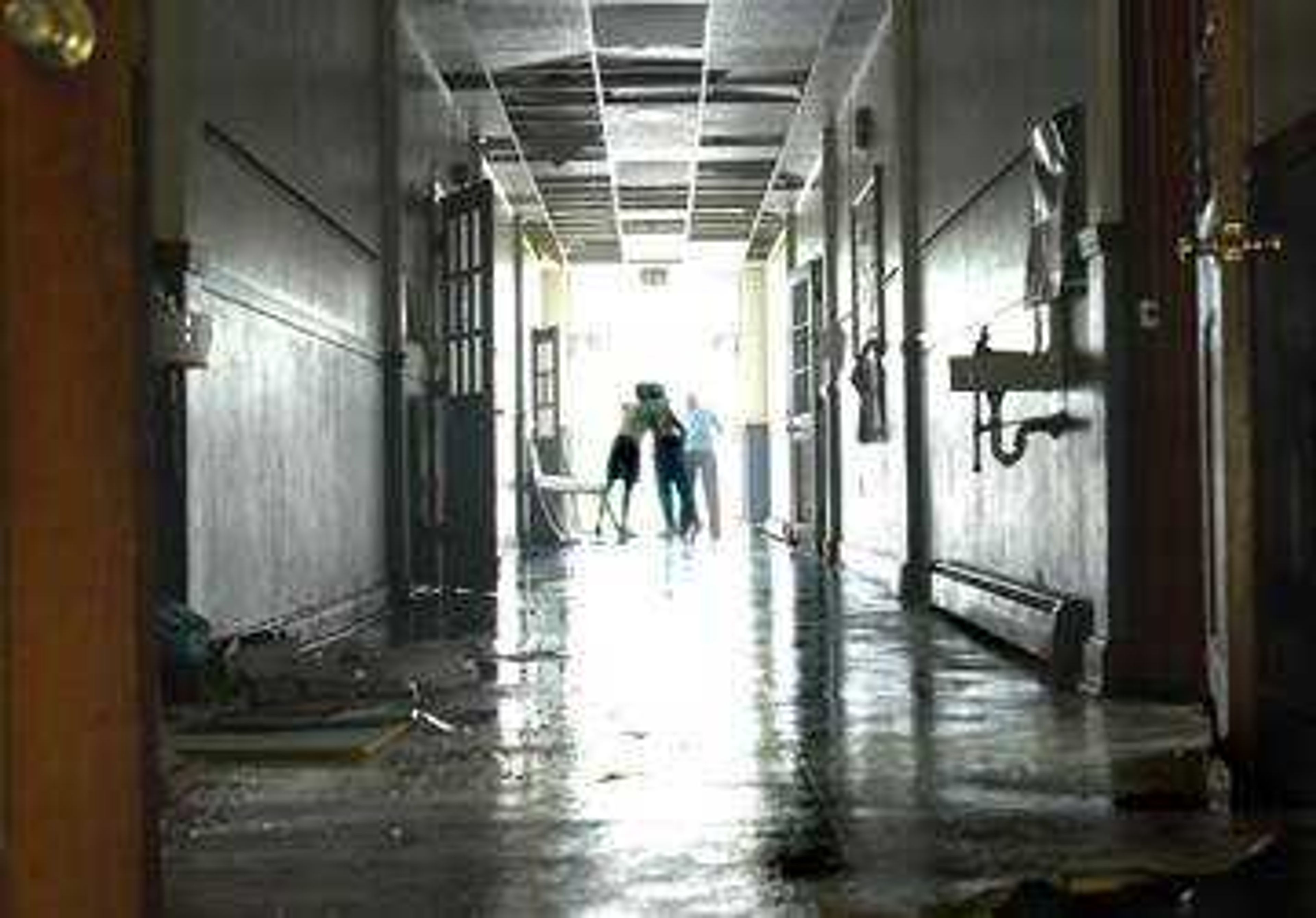 Darlene Bullinger hugged Janell Hinkebein in the flooded hallway of Immaculate Conception School in Jackson.  The school suffered severe damages during Tuesday's storm and will be closed until further notice.