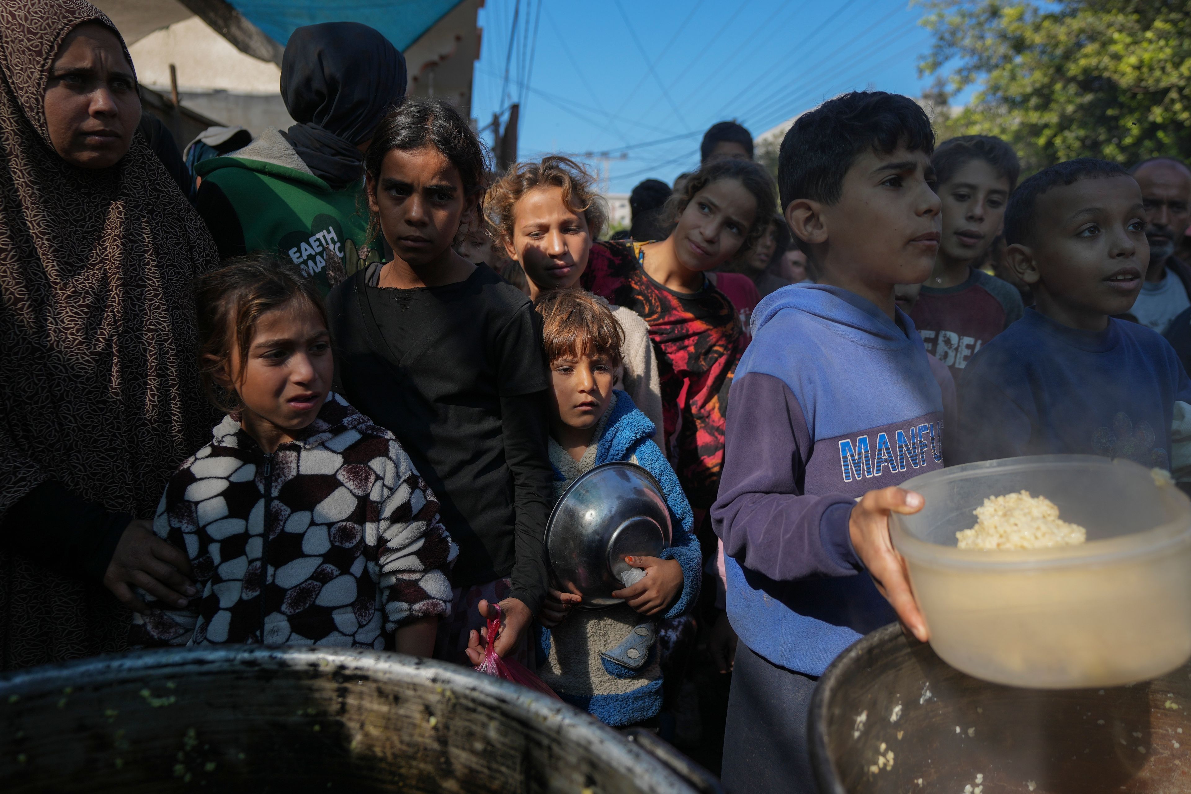 Palestinian children queue at a food distribution kitchen in Deir al-Balah, Gaza Strip, Friday Nov. 22, 2024. (AP Photo/Abdel Kareem Hana)