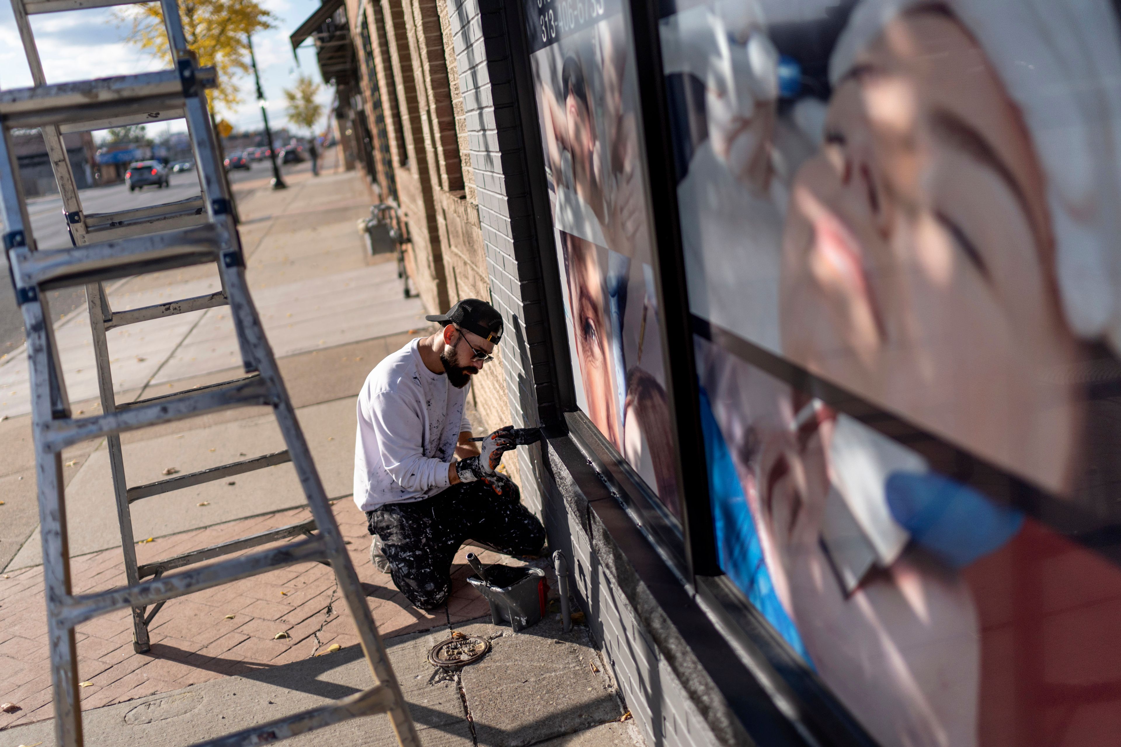 Adam Hameed, paints the exterior of a skin care center, Wednesday, Nov. 6, 2024, in Dearborn, Mich., the nation's largest Arab-majority city. (AP Photo/David Goldman)