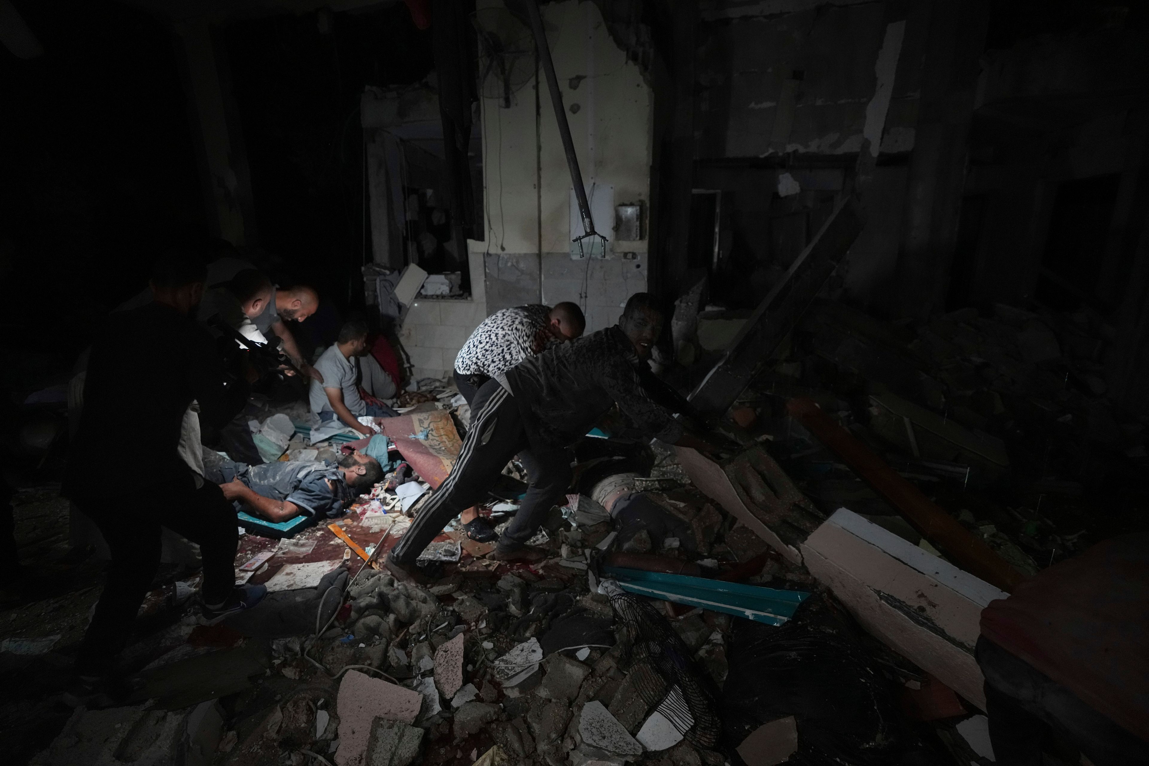 Palestinians search for survivors and bodies in the rubble of a mosque destroyed in an Israeli airstrike in Deir al-Balah, Sunday, Oct. 6, 2024. (AP Photo/Abdel Kareem Hana)