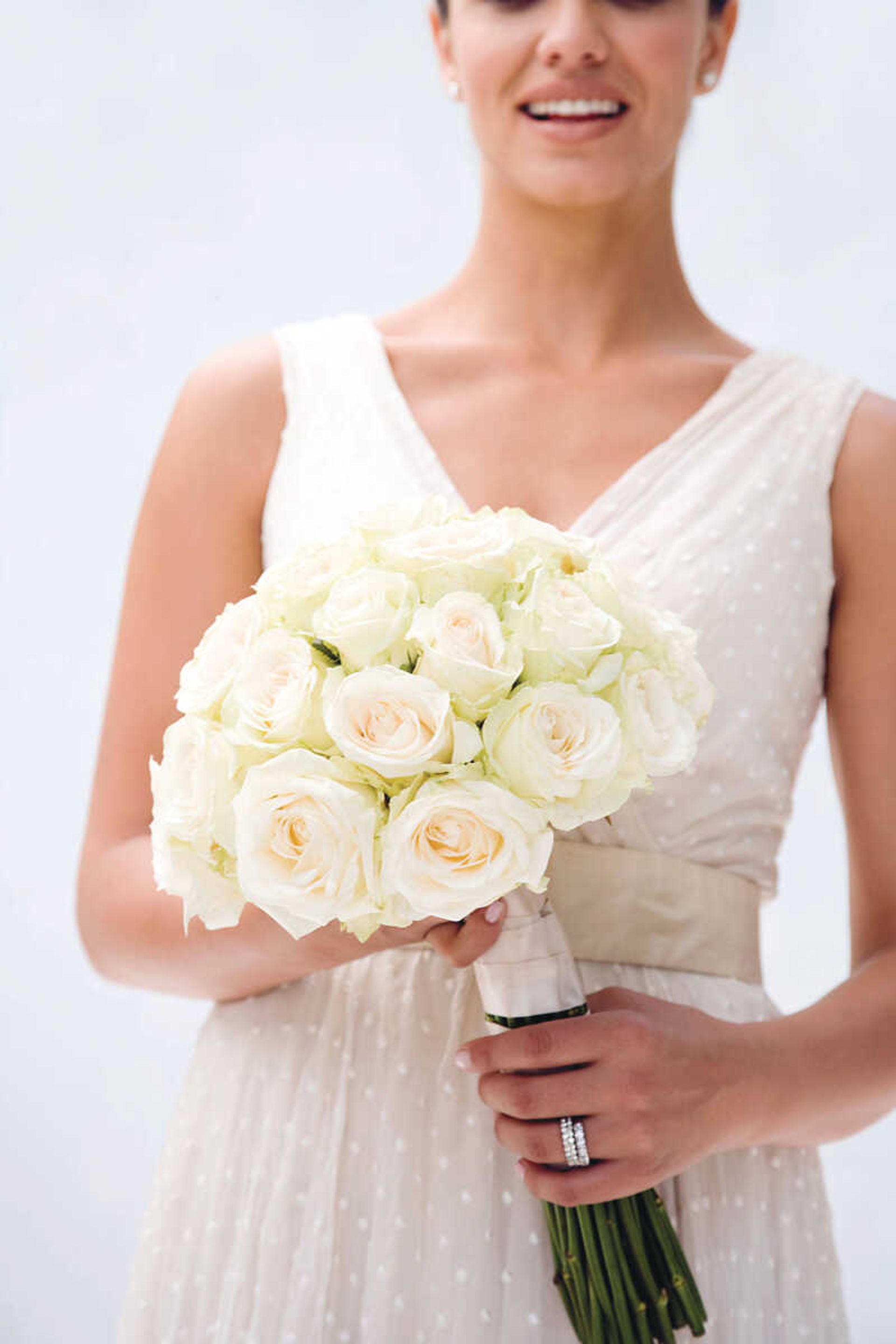 Bride holding bouquet of roses