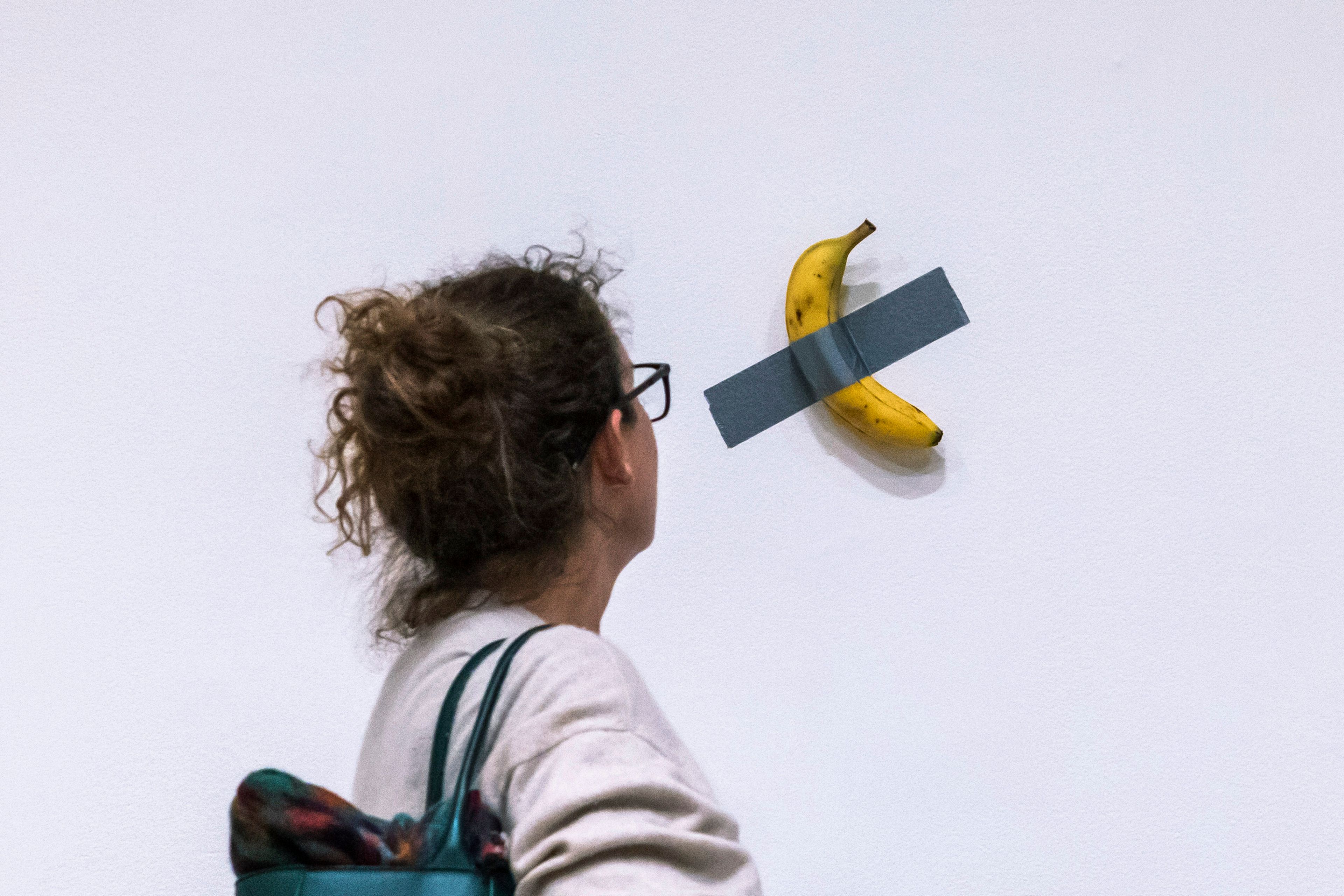 File - A woman looks at artist Maurizio Cattelan's piece of art "Comedian" during an auction preview at Sotheby's in New York, Monday, Nov. 11, 2024. (AP Photo/Eduardo Munoz Alvarez, File)