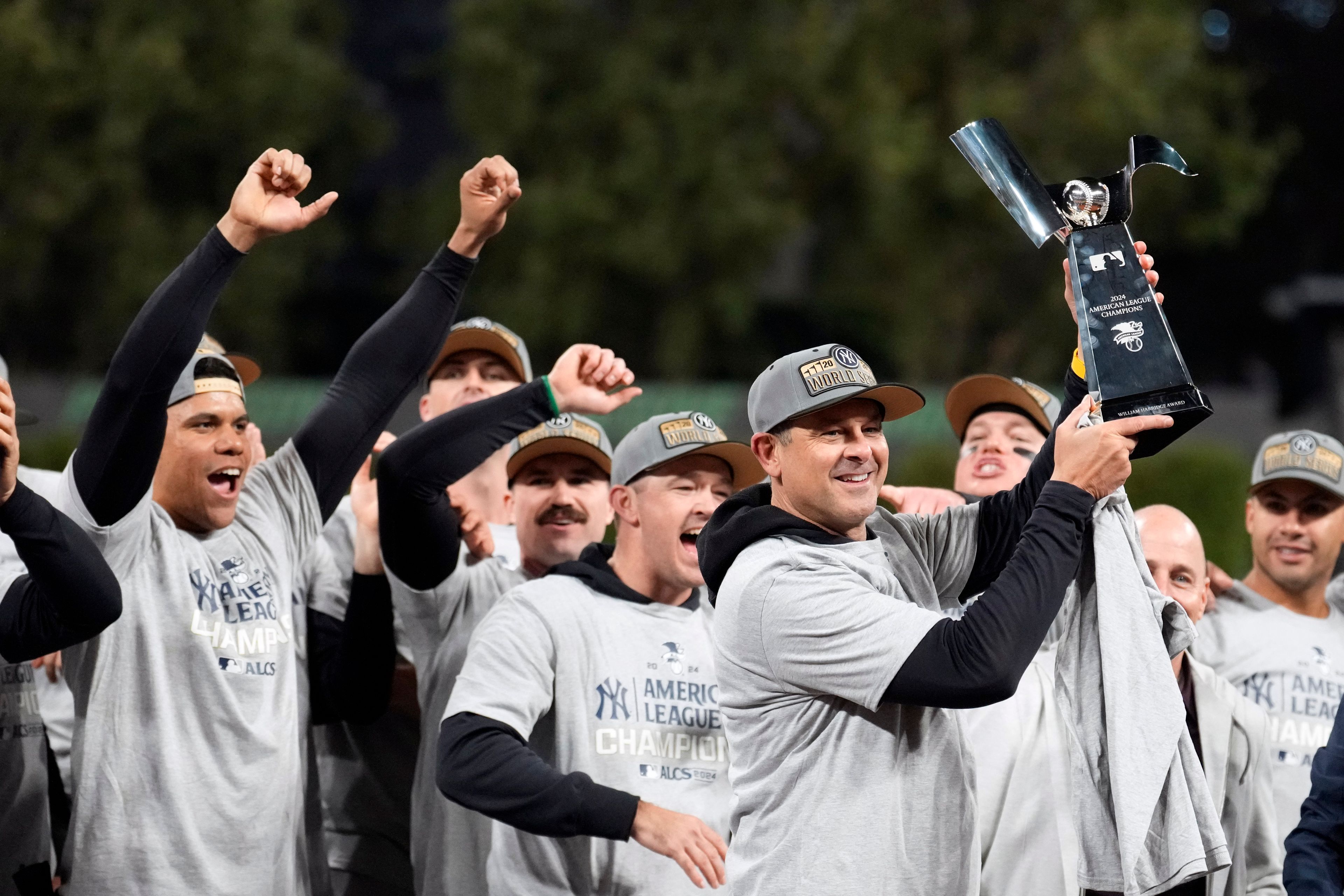 New York Yankees manager Aaron Boone holds up the American League Championship trophy after Game 5 of the baseball AL Championship Series against the Cleveland Guardians Sunday, Oct. 20, 2024, in Cleveland. The Yankees won 5-2 to advance to the World Series. (AP Photo/Sue Ogrocki)