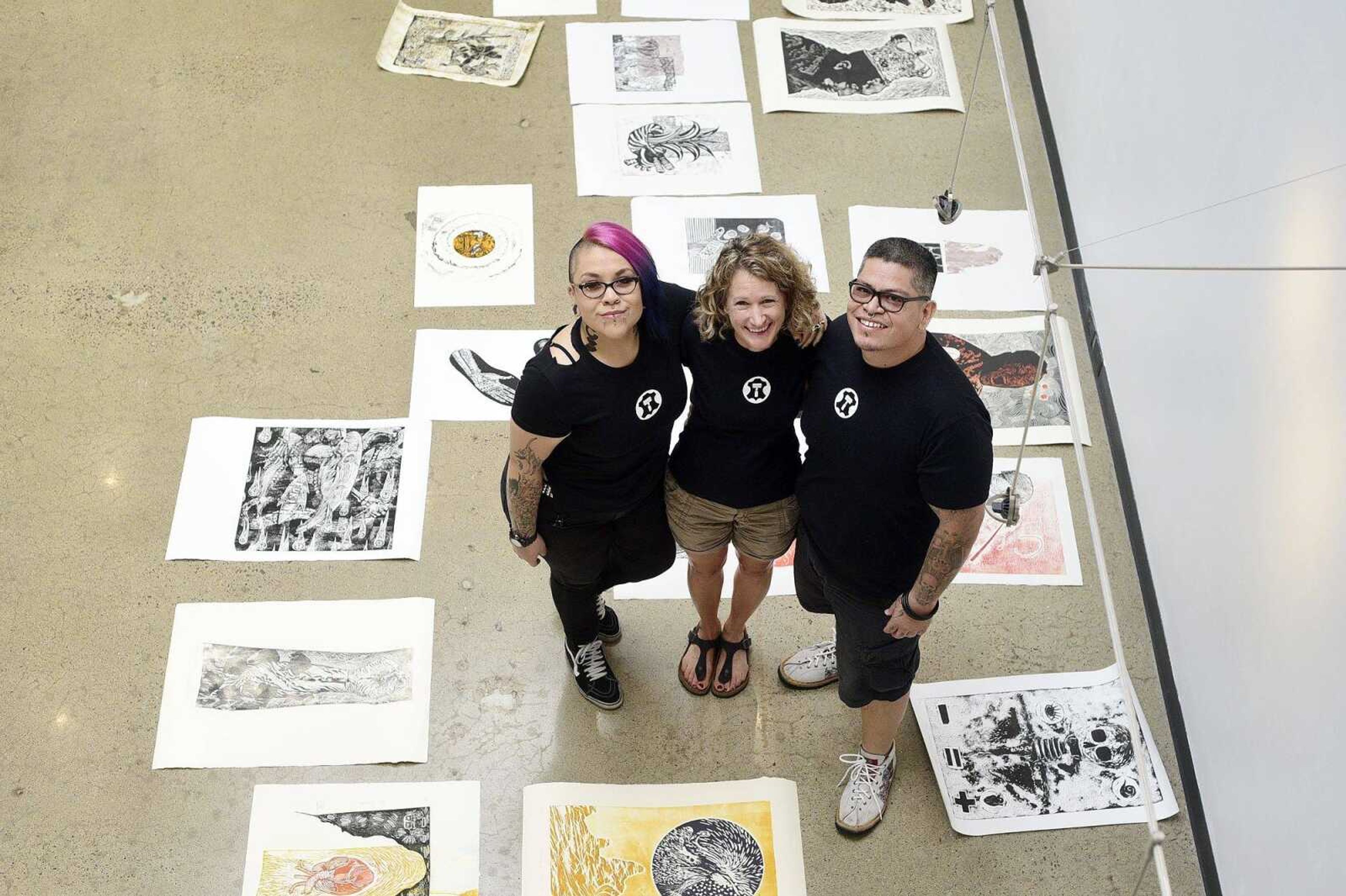 Alejandra Mares, left, Joni Hand and Xavier Moreno pose for a photo before hanging artwork for an upcoming show at Catapult Creative House in Cape Girardeau.