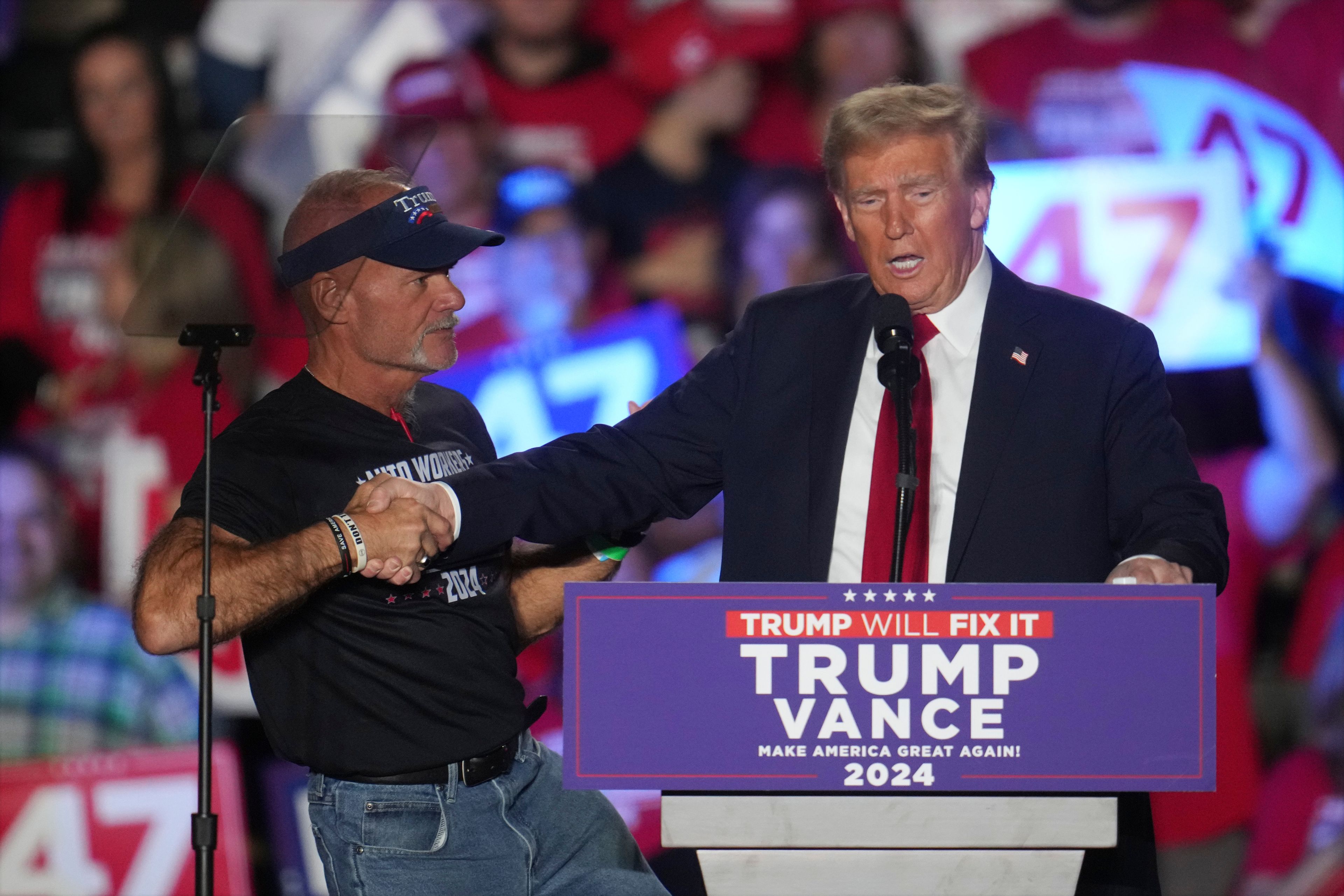 Republican presidential nominee former President Donald Trump shakes hands with Brian Pannebecker as he speaks at a campaign rally at Macomb Community College Friday, Nov. 1, 2024, in Warren, Mich. (AP Photo/Paul Sancya)