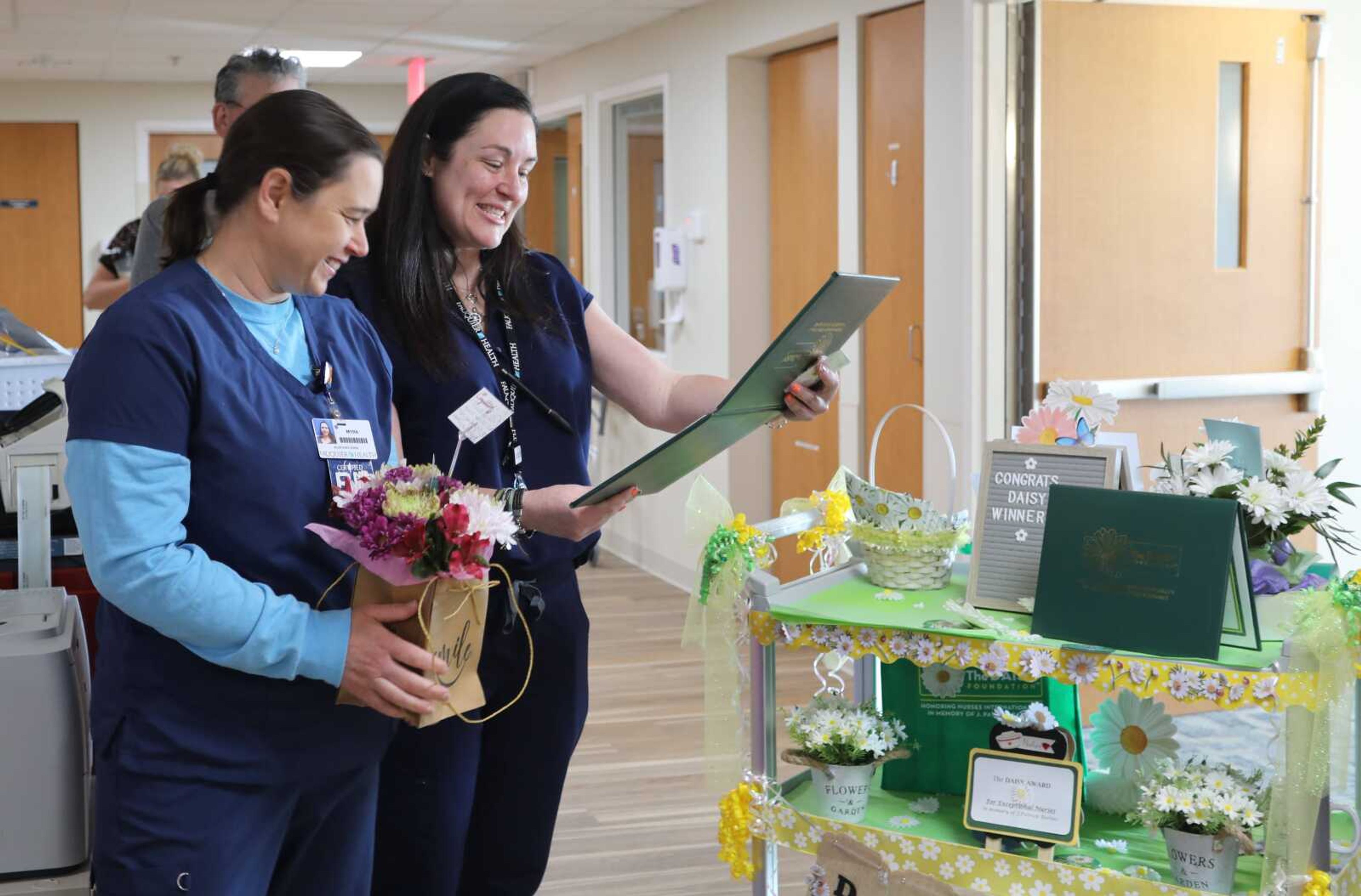 Toni Maxwell, Fauquier Health Chief Nursing Officer, awards Myra Griffen the DAISY award.