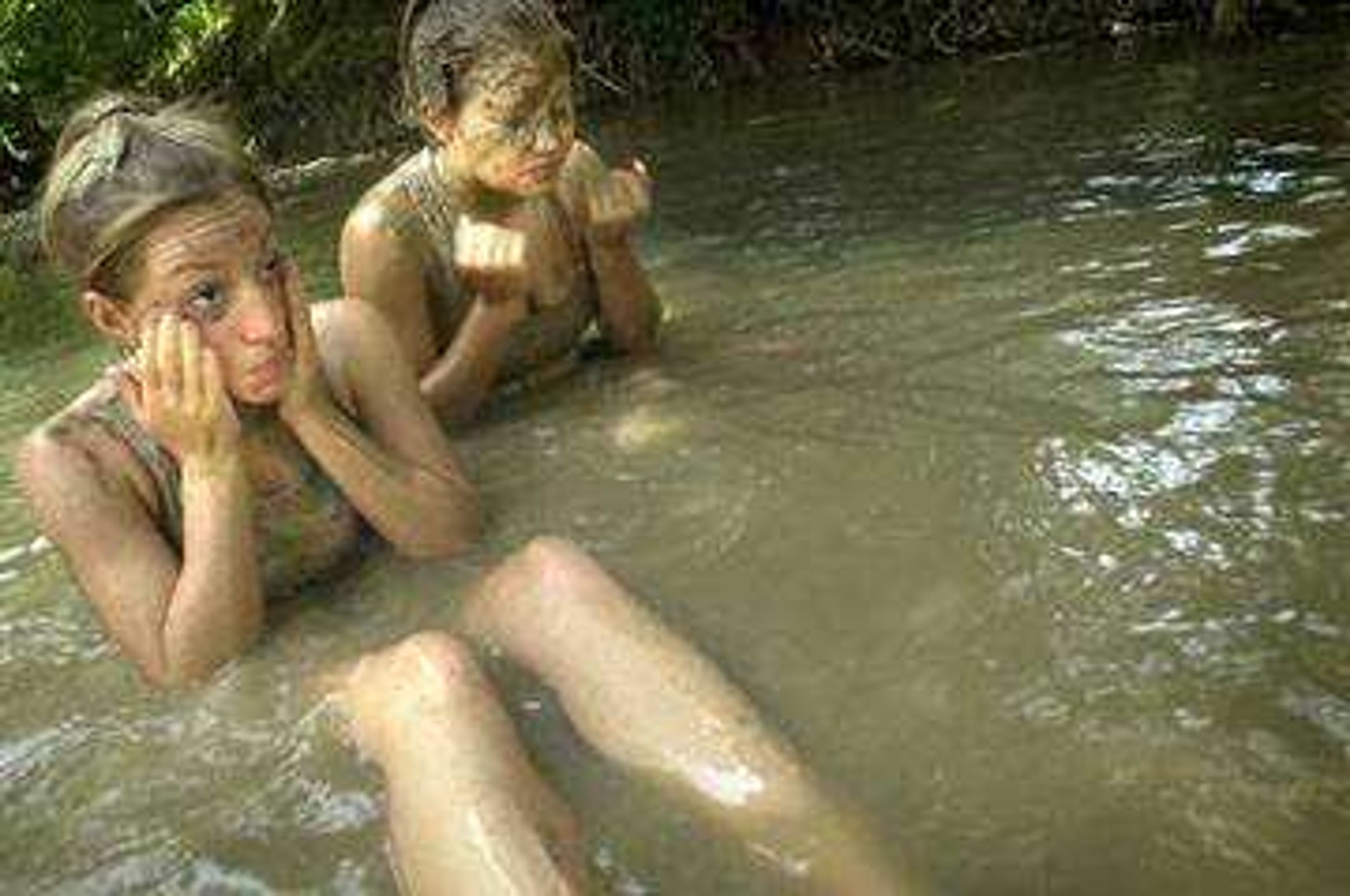 Jacie Hartle and Melanie Essner of Jackson washed the mud off of themselves in the creek after their volleyball match.