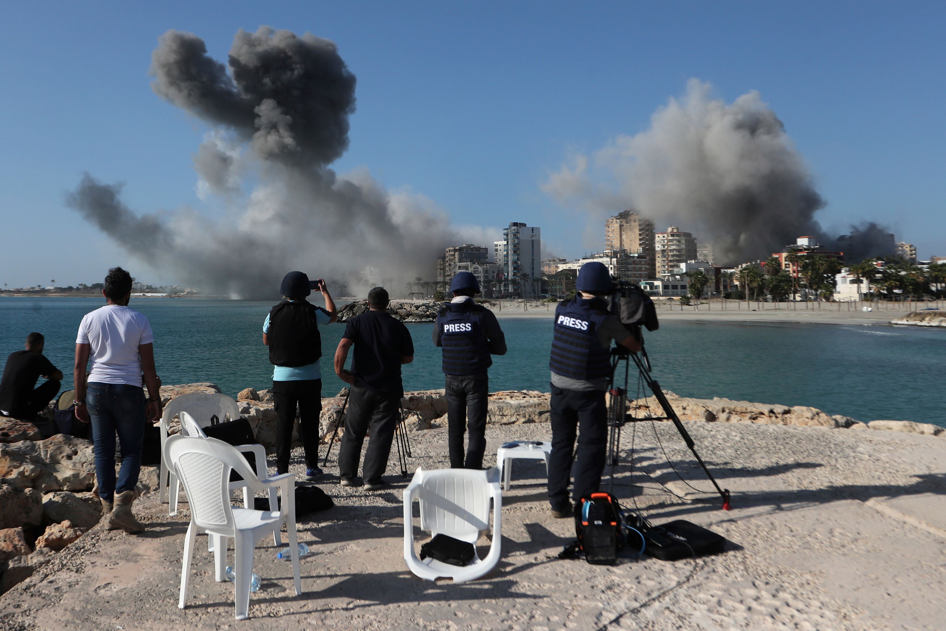 Journalists film as smoke rises from buildings hit in Israeli airstrikes in Tyre, southern Lebanon, Monday, Oct. 28, 2024.(AP Photo/Mohammed Zaatari)