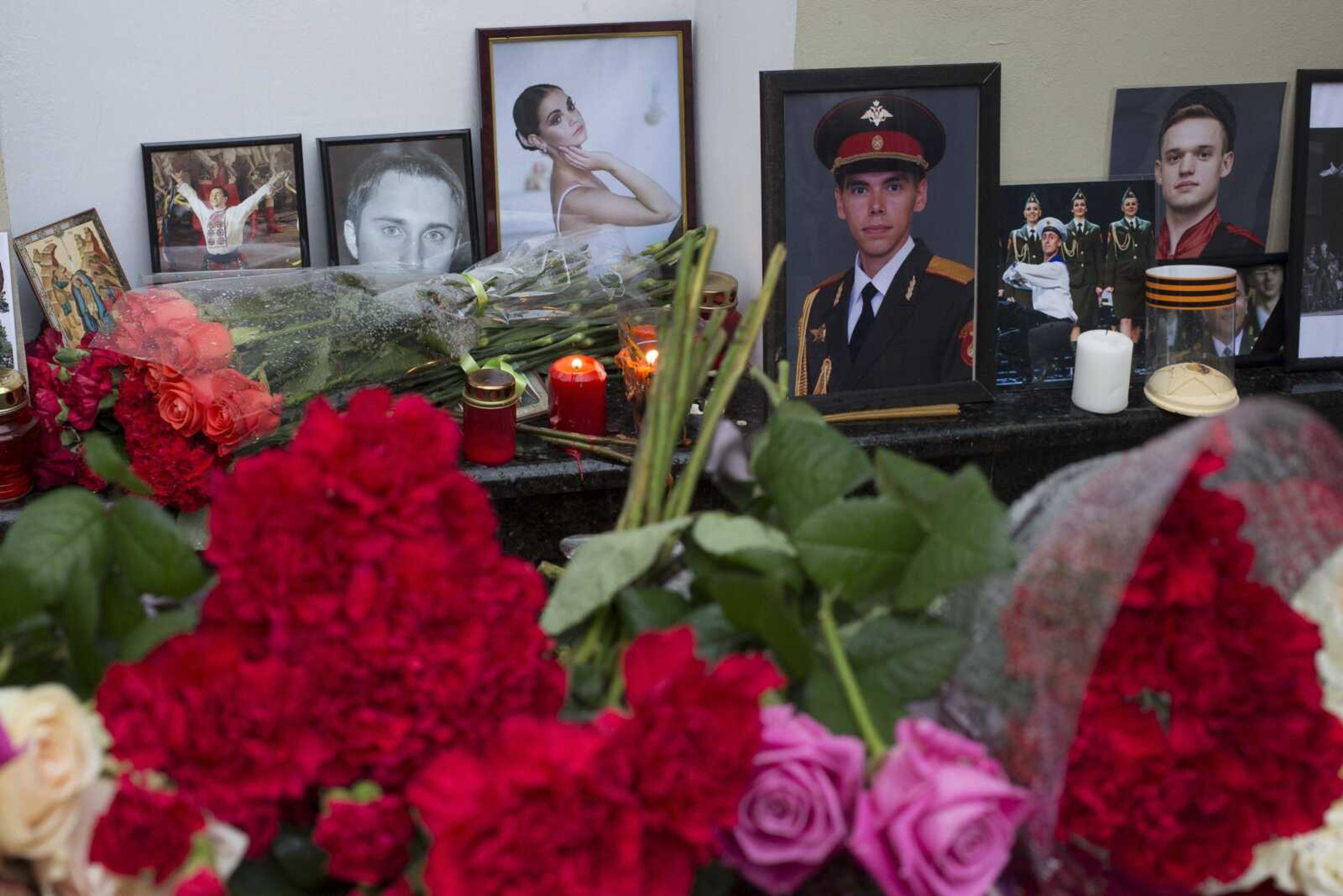 Portraits of the Alexandrov Ensemble members are placed Tuesday with candles and flowers in front of the Alexandrov Ensemble building in Moscow. A plane carrying 64 members of the Alexandrov Ensemble crashed Sunday into the Black Sea minutes after taking off from the resort city of Sochi.