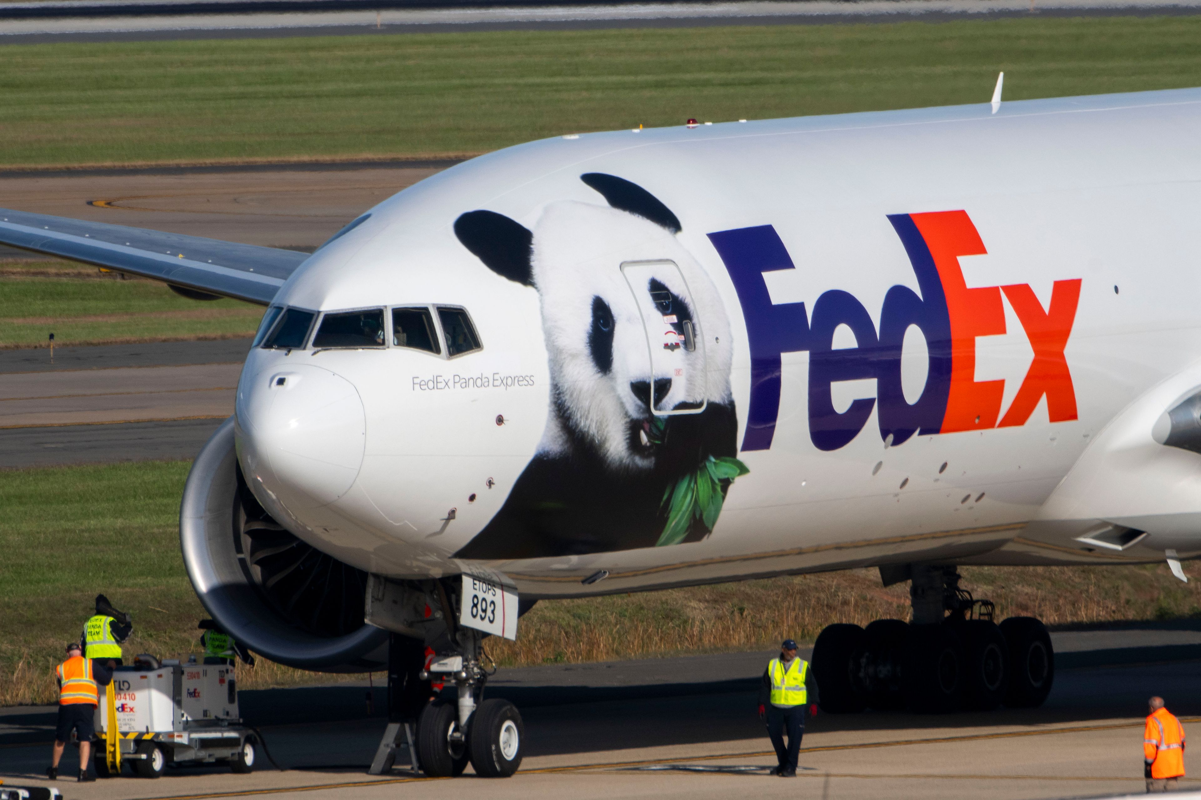 Ground crew walk up to a FedEx cargo plane carrying giant pandas from China after it landed at Dulles International Airport on Tuesday, Oct. 15, 2024 in Sterling, Va. (AP Photo/Kevin Wolf)