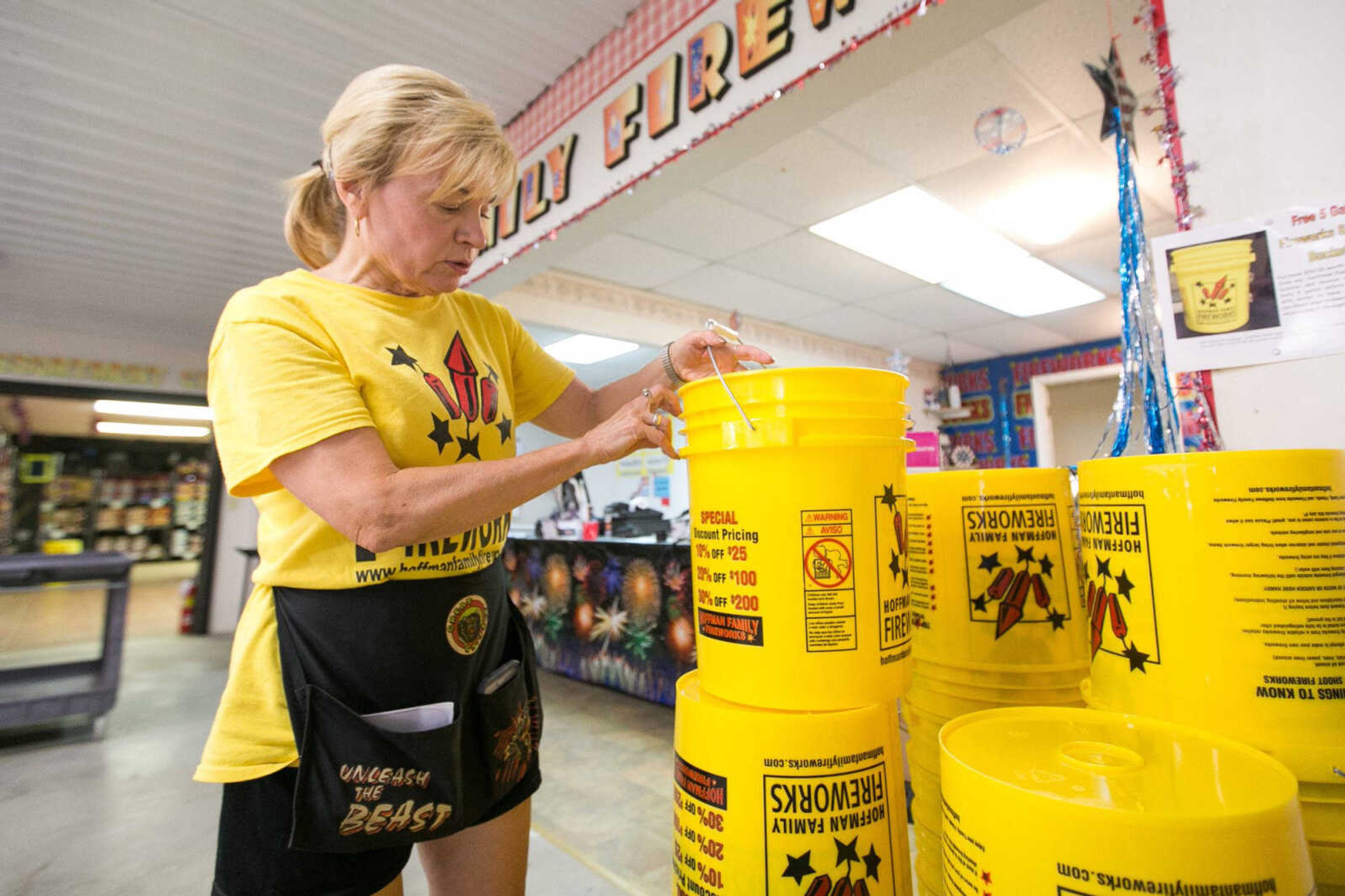 Mary Ann Hoffman explains the uses for a five gallon safety bucket being handed out at Hoffman Family Fireworks as part of a promotion Thursday in Scott City.