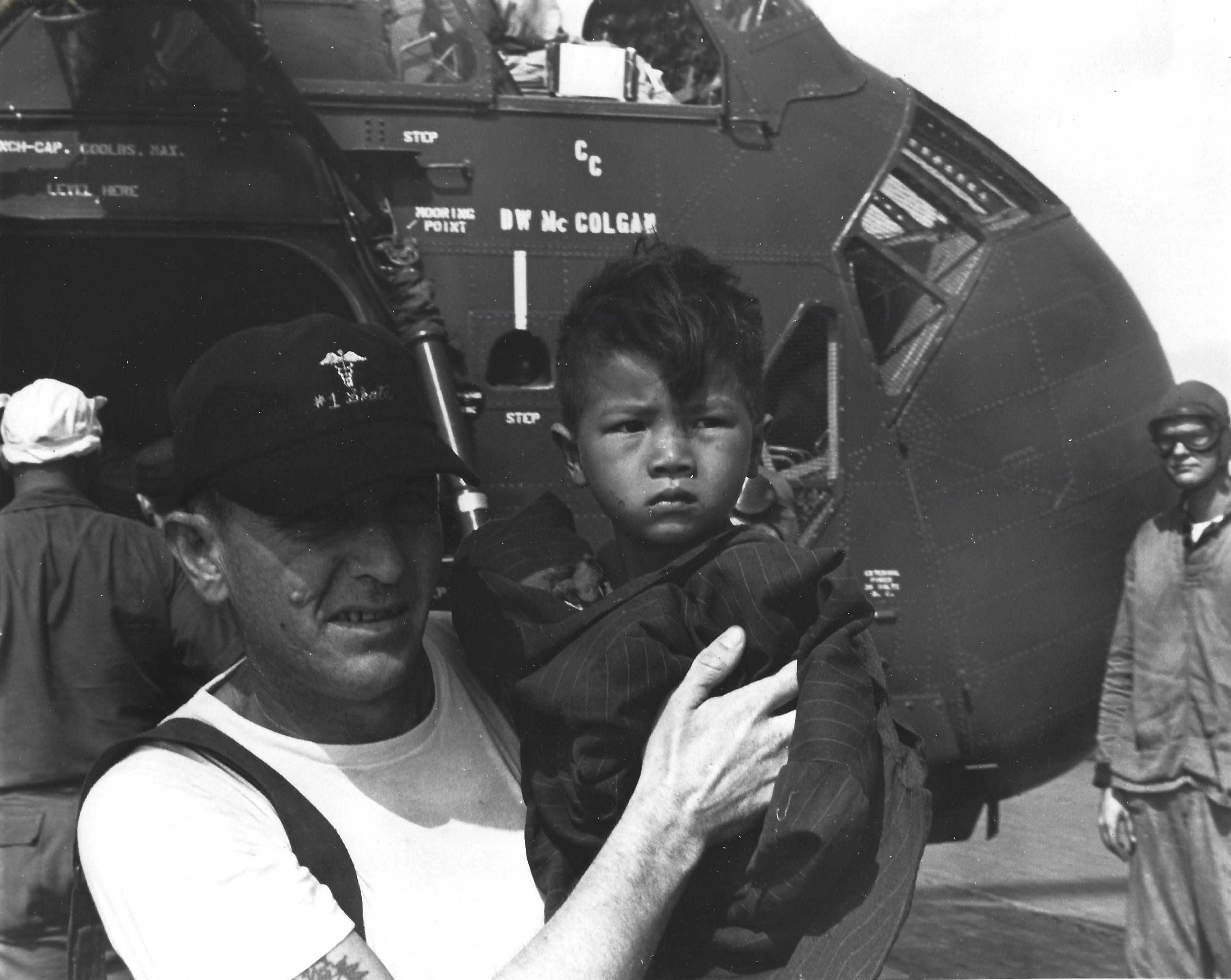 A United States serviceman holds a Vietnamese boy. Red Clifton Collection.
