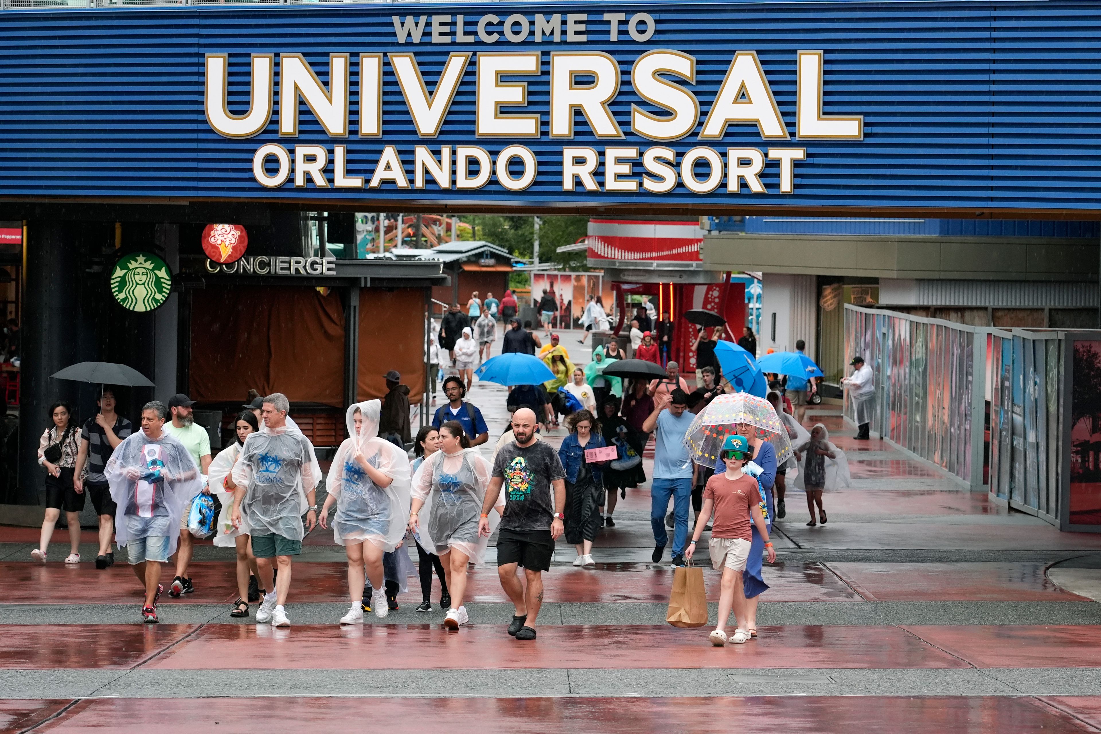 Tourists exit Universal Orlando Resort as they were closing early for the arrival of Hurricane Milton Wednesday, Oct. 9, 2024, in Orlando, Fla. (AP Photo/John Raoux)