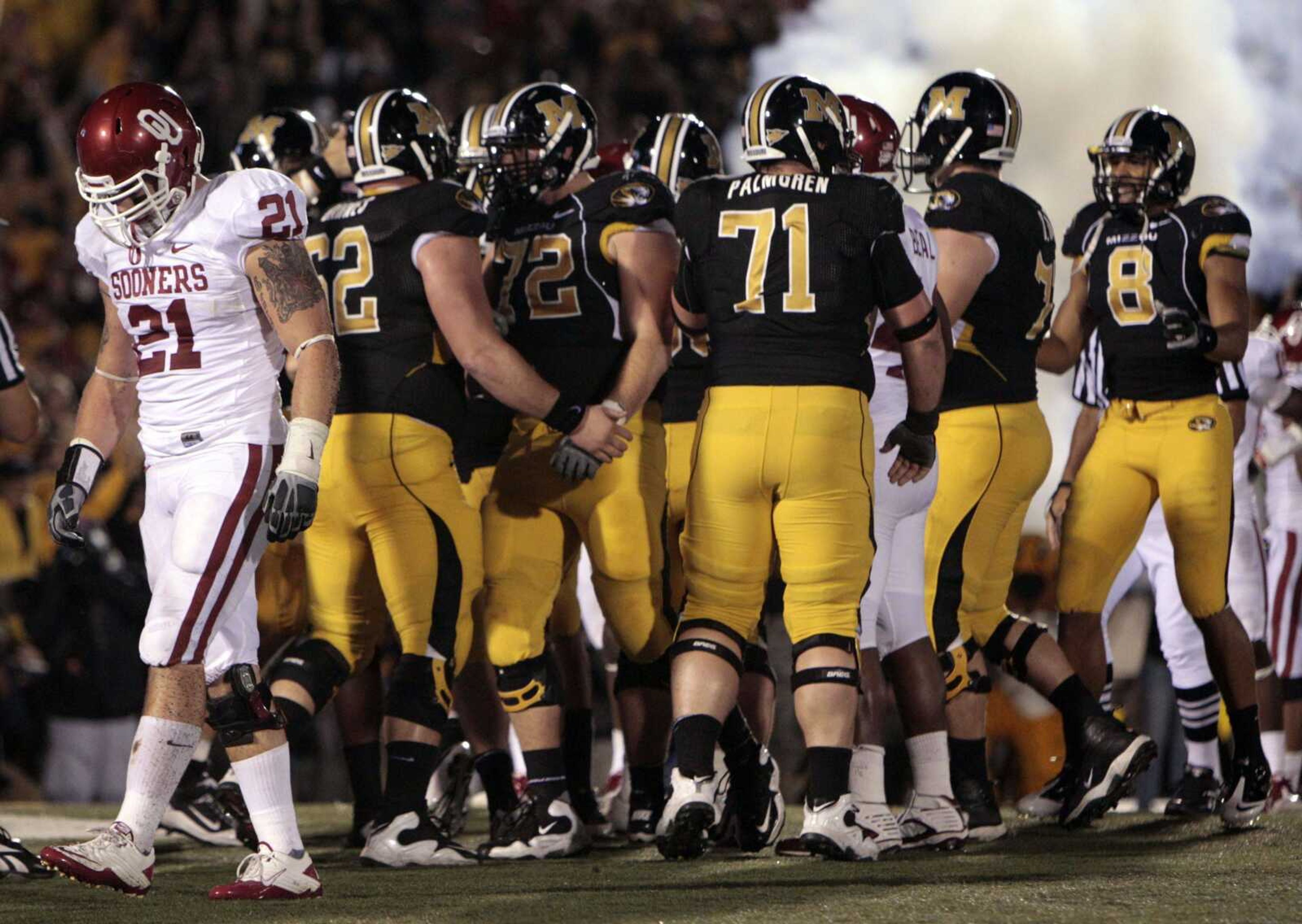 Oklahoma Sooners linebacker Tom Wort (21) walks away as Missouri Tigers celebrate a 3-yard touchdown run by teammate James Franklin during the fourth quarter of an NCAA college football game Saturday, Oct. 23, 2010, in Columbia, Mo. Missouri won 36-27. (AP Photo/Jeff Roberson)