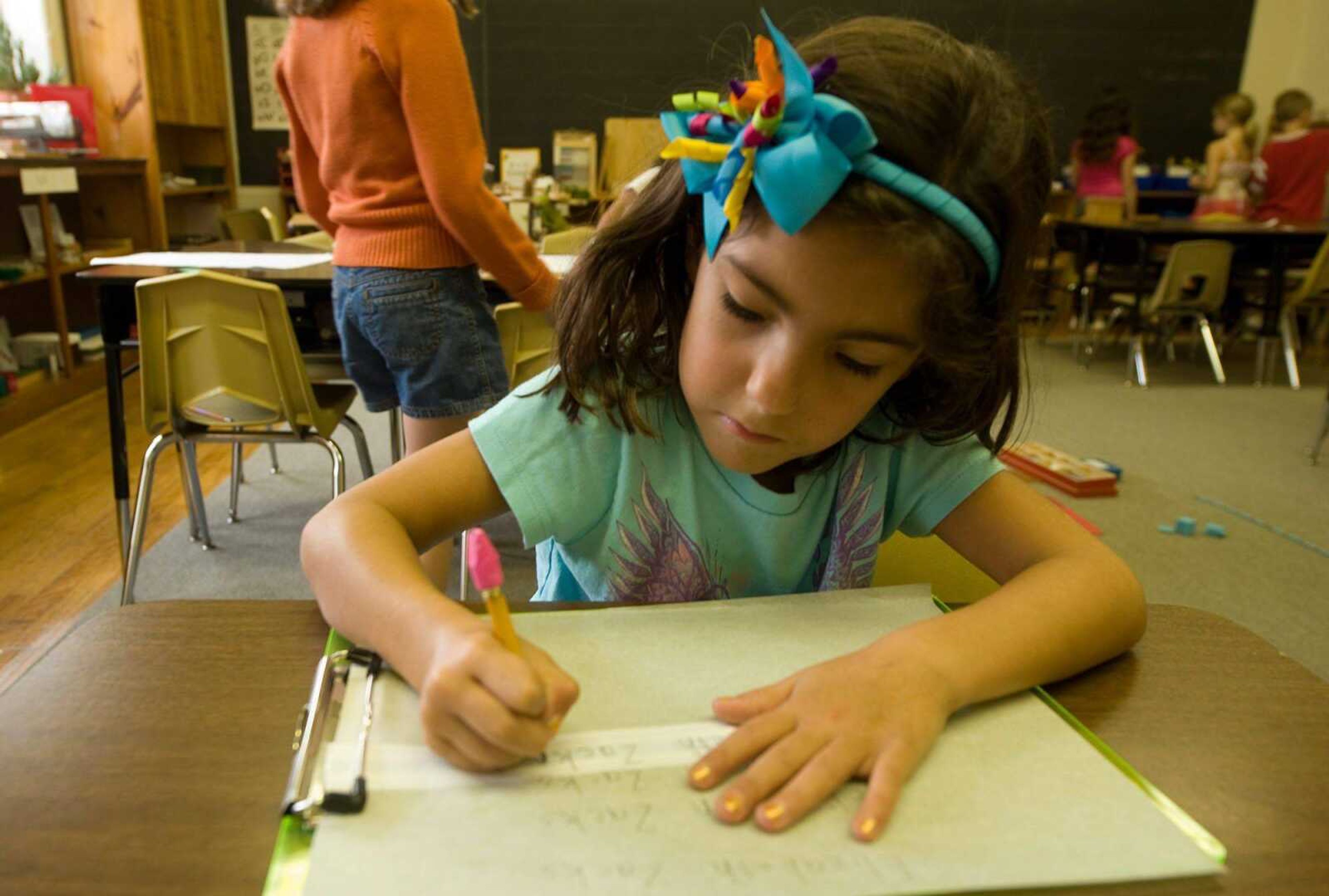 Elizabeth Zacks practicing printing her name Sept. 16 at the Mountaineer Montessori School in Charleston, W.Va. The decline of cursive is happening as students are doing more and more work on computers. (BOB BIRD ~ Associated Press)