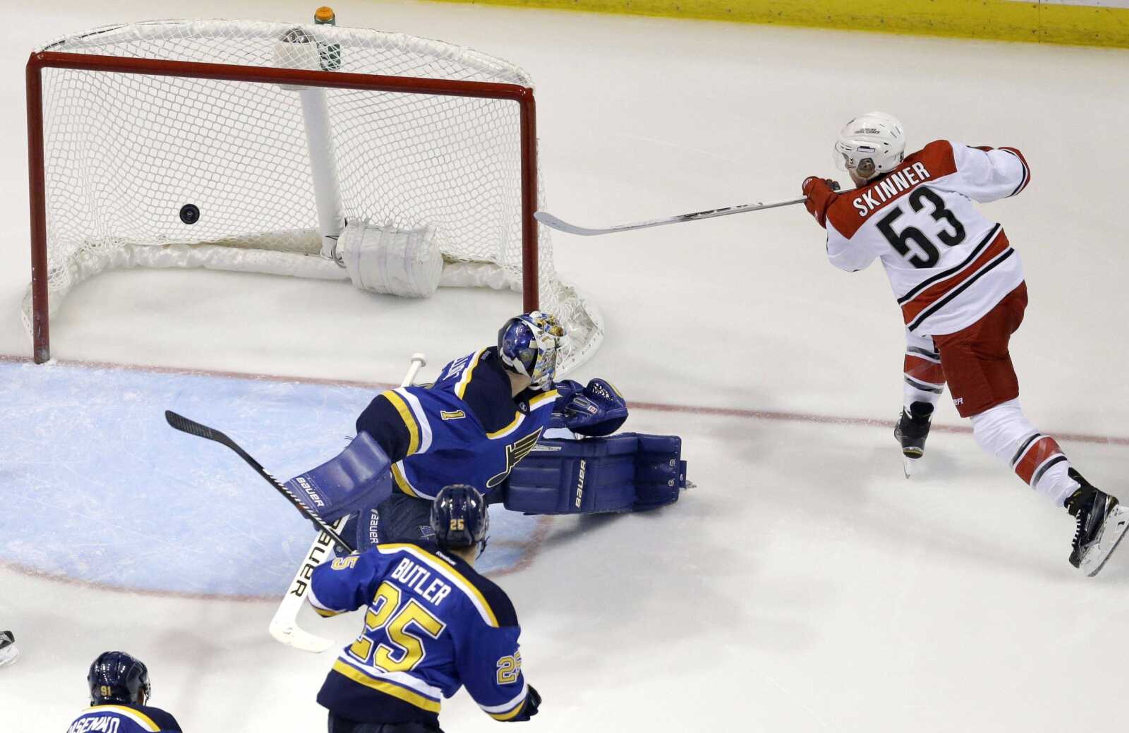 The Hurricanes' Jeff Skinner scores past Blues goalie Brian Elliott and Chris Butler during the second period Thursday in St. Louis. Carolina won 4-1. (Jeff Roberson ~ Associated Press)