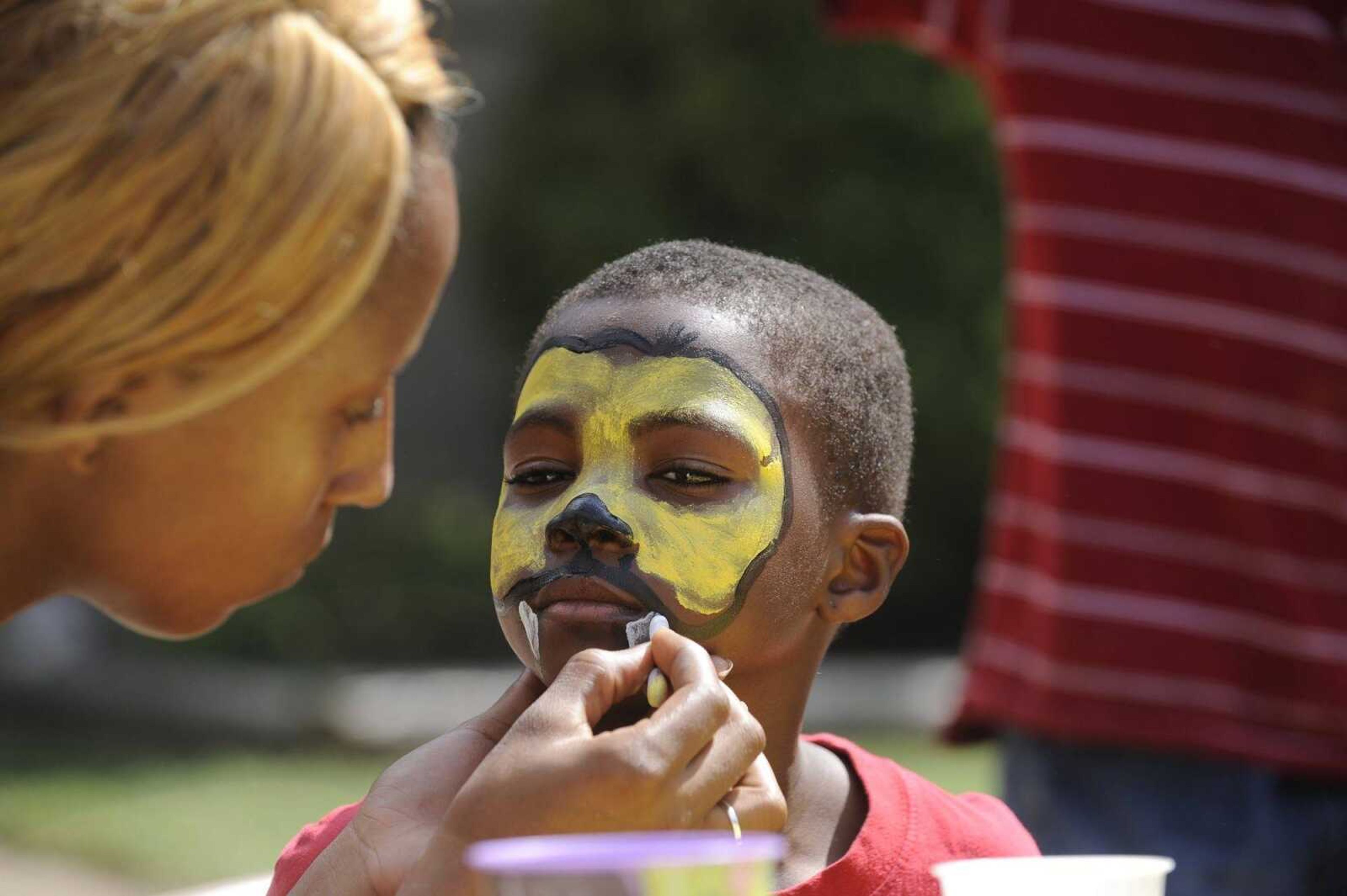 Tyrique Lockridge, 8, gets a cheetah painted on his face by ZuVonda Richardson at the 2014 block party in Cape Girardeau. (Glenn Landberg)