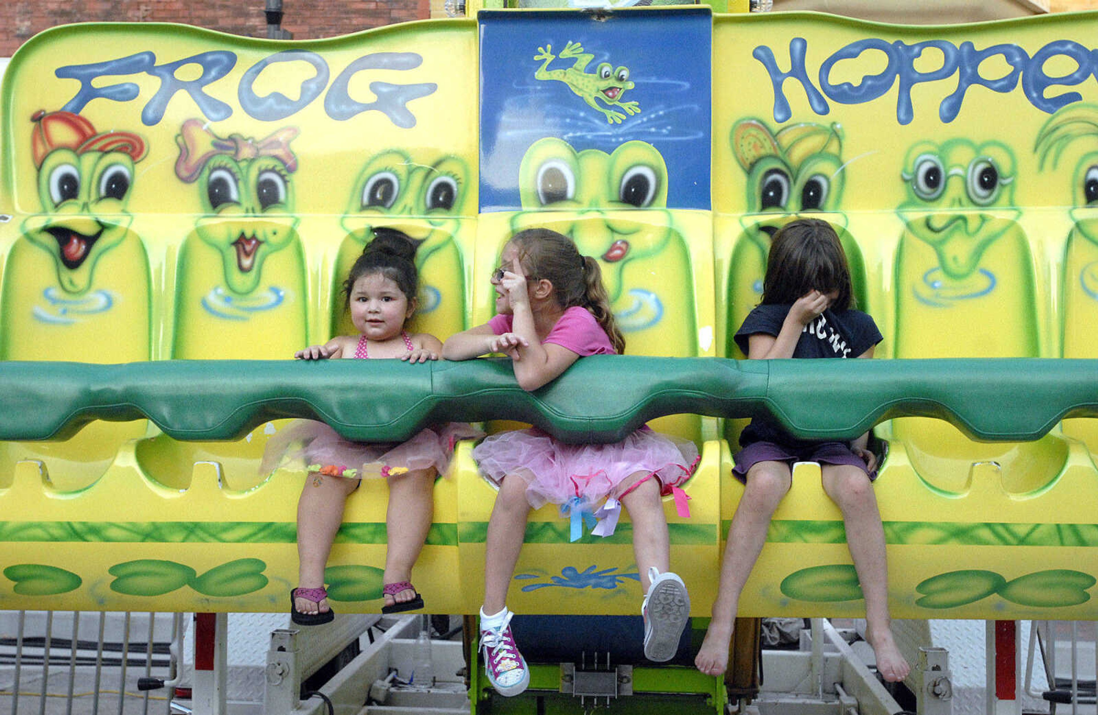 LAURA SIMON ~ lsimon@semissourian.com
Alaina Boyer, left, listens as Ashleigh Kennedy asks to the Frog Hopper operator to ride again  Wednesday, July 27, 2011 during Jackson Homecomers.