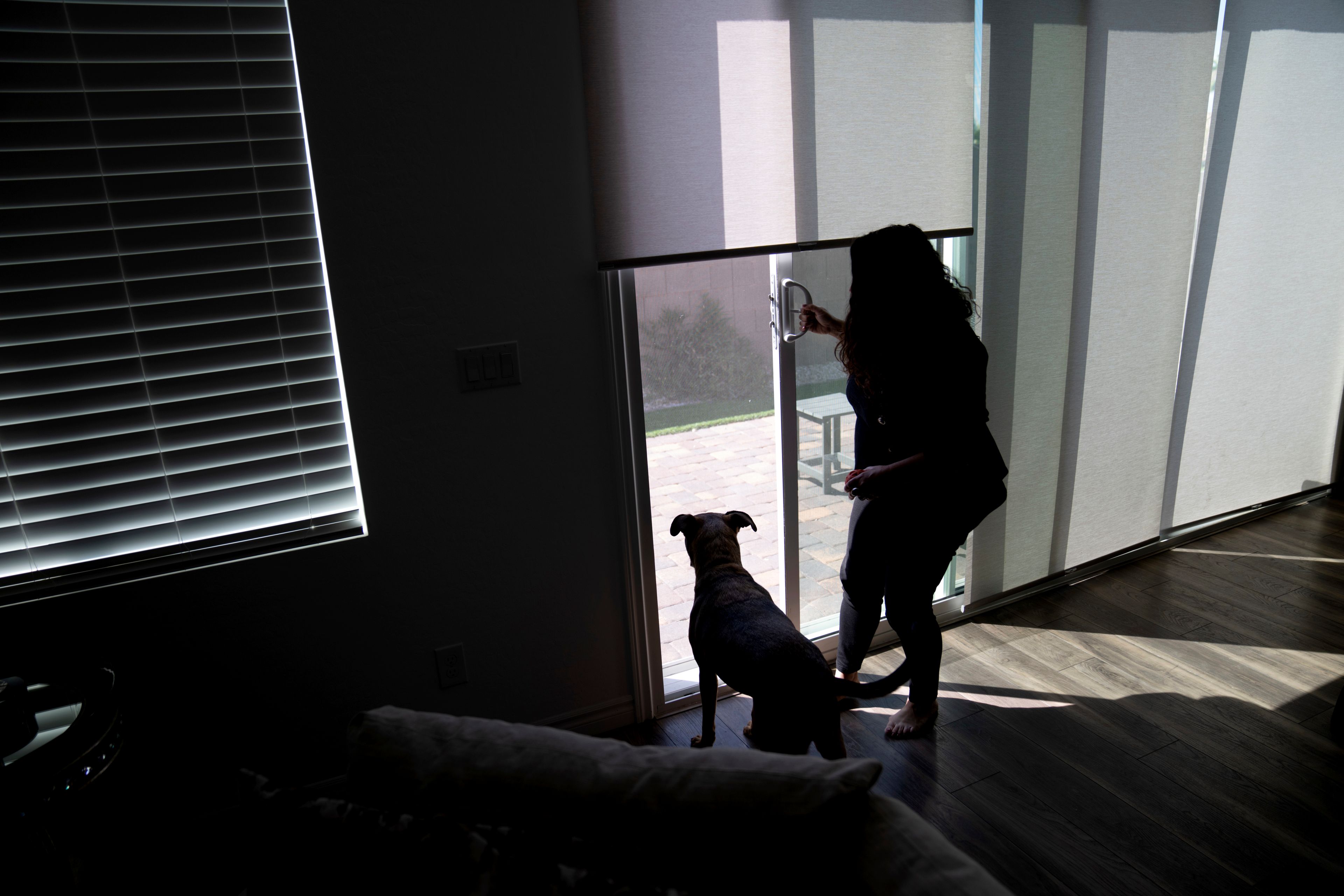 Buttons lets out her friend's dog, while visiting her home in Monday, June 24, 2024, in Henderson, Nev. Buttons' parents brought her to the United States on a tourist visa, which in the eyes of the government she soon overstayed as a toddler, and that is an offense that cannot be rectified. (AP Photo/David Goldman)