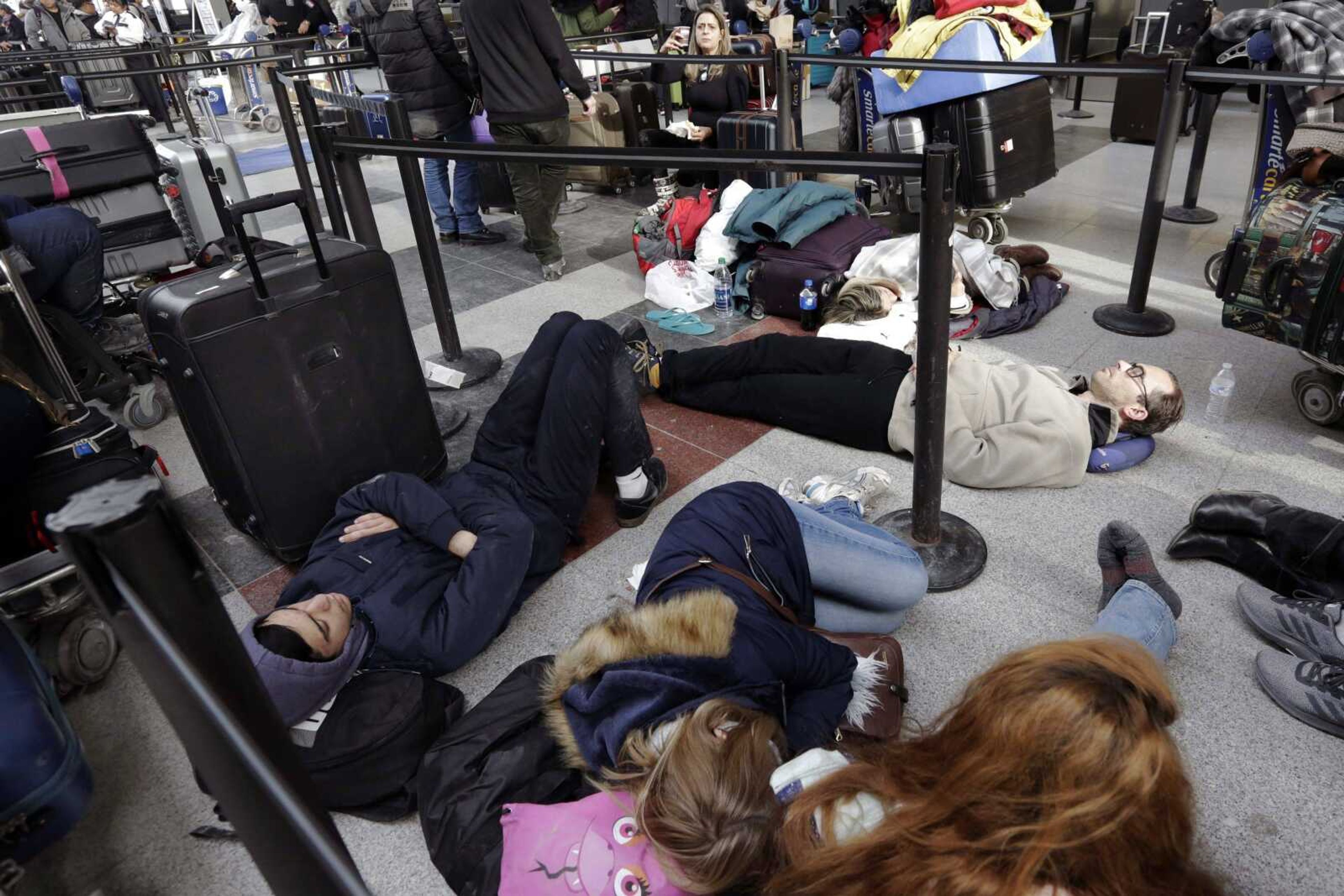 Avianca passengers lay on the floor Monday while waiting for their flight at John F. Kennedy Airport Terminal 4 in New York. Some passengers have been stranded for days after their flights were canceled due to weather and the bursting of a water pipe.