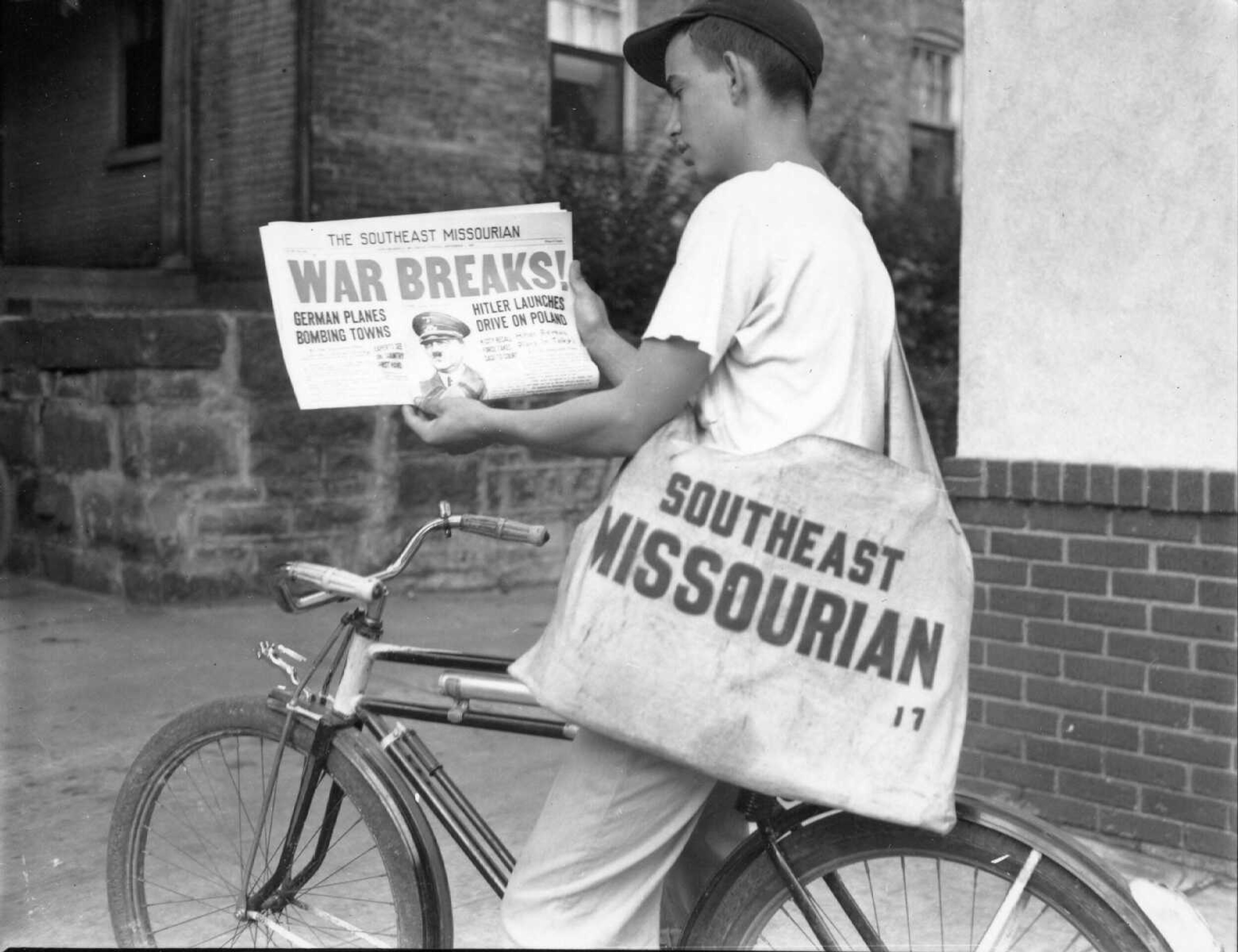 Published 1 Sept. 1939. The Missourian's carrier boys rolled out of bed early this morning to do their part toward bringing the news of the outbreak of the European war to Cape Girardeau readers. Shown above is a typical carrier, Charles Riemann, 17, of the Koch suburb, shown astride his bicycle scanning a copy of the early "extra" that brought the first authentic word of the start of the conflict. Riemann was just one of dozens of boys in town served by The Missourian who saw to it their subscribers got a copy of the "extra" as a matter of service.