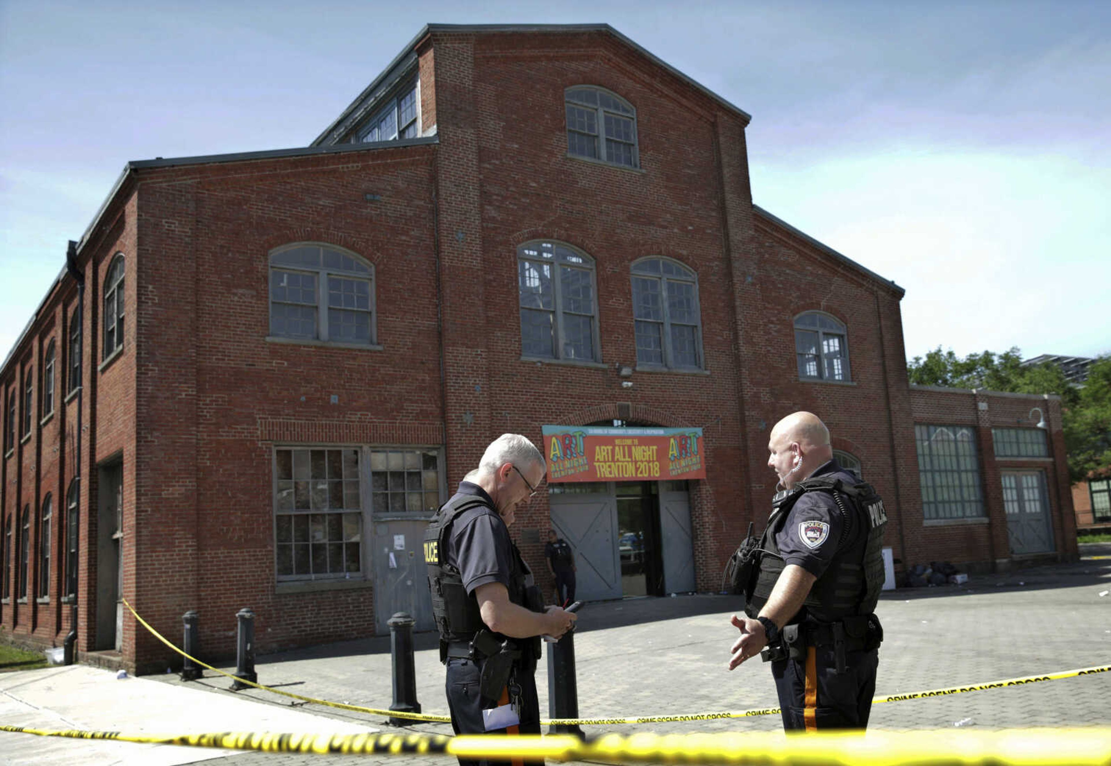 Police stand guard outside the warehouse building Sunday where the Art All Night Trenton 2018 festival was held that was the scene of a shooting resulting in numerous injuries and at least one death in Trenton, New Jersey.