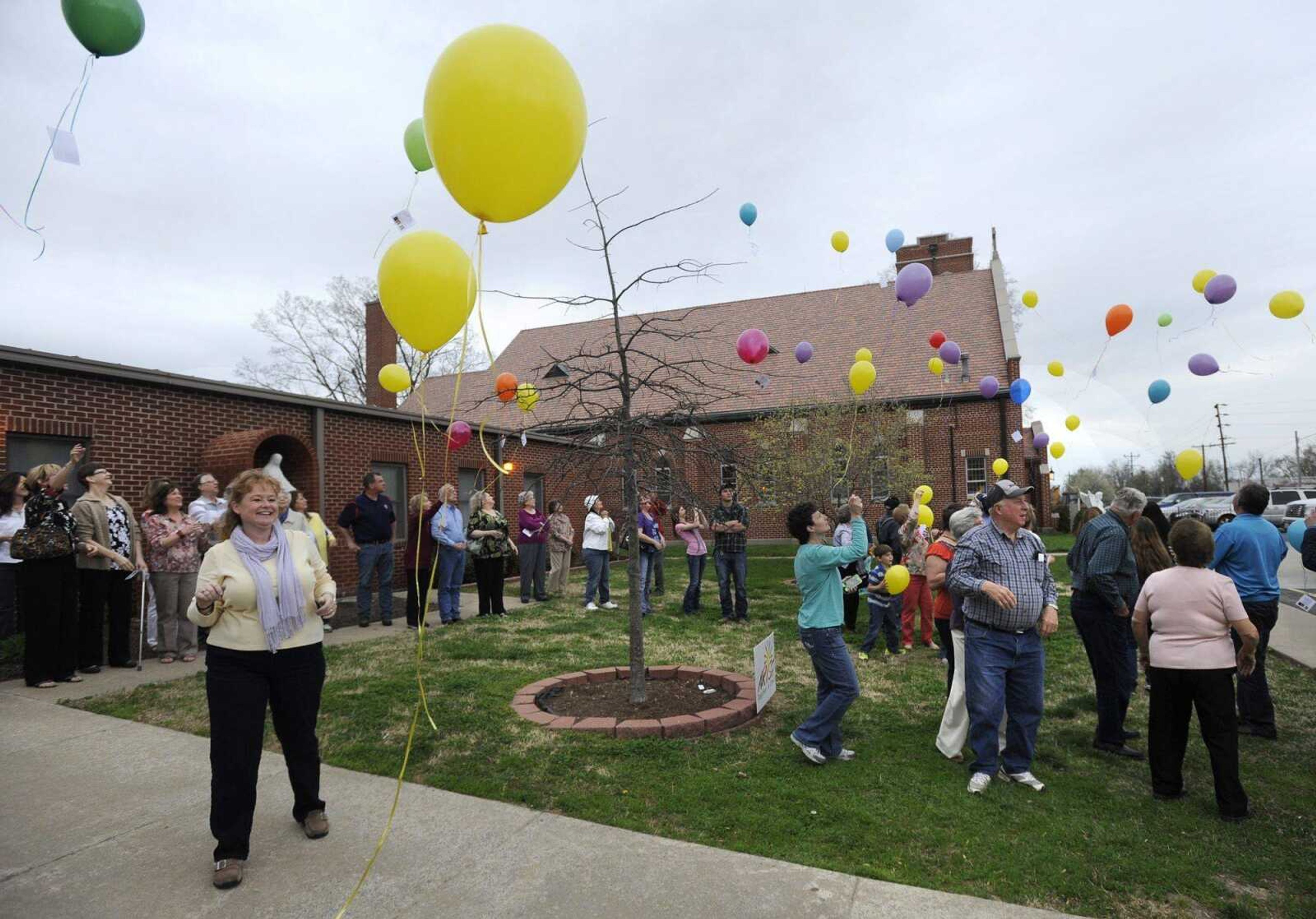 Diane Scherer-Morris, left, releases balloons with friends and family of her sister, Cheryl Scherer, Sunday, April 13, 2014 at St. Denis Parish in Benton, Mo. Scherer disappeared April 17, 1979. (Fred Lynch)