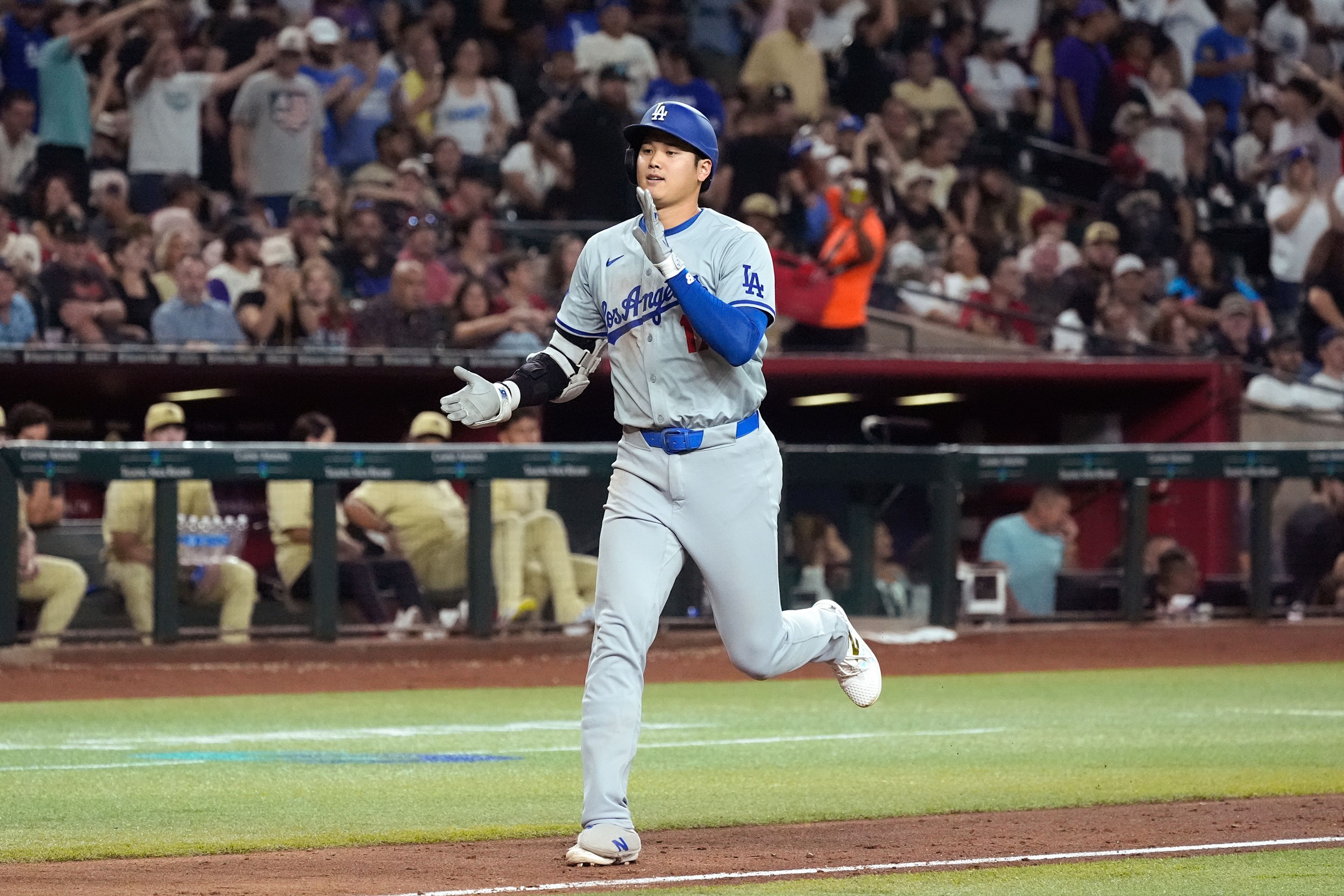 Los Angeles Dodgers designated hitter Shohei Ohtani, of Japan, claps has he rounds the bases after hitting a home run against the Arizona Diamondbacks during the eighth inning of a baseball game Friday, Aug. 30, 2024, in Phoenix. (AP Photo/Ross D. Franklin)