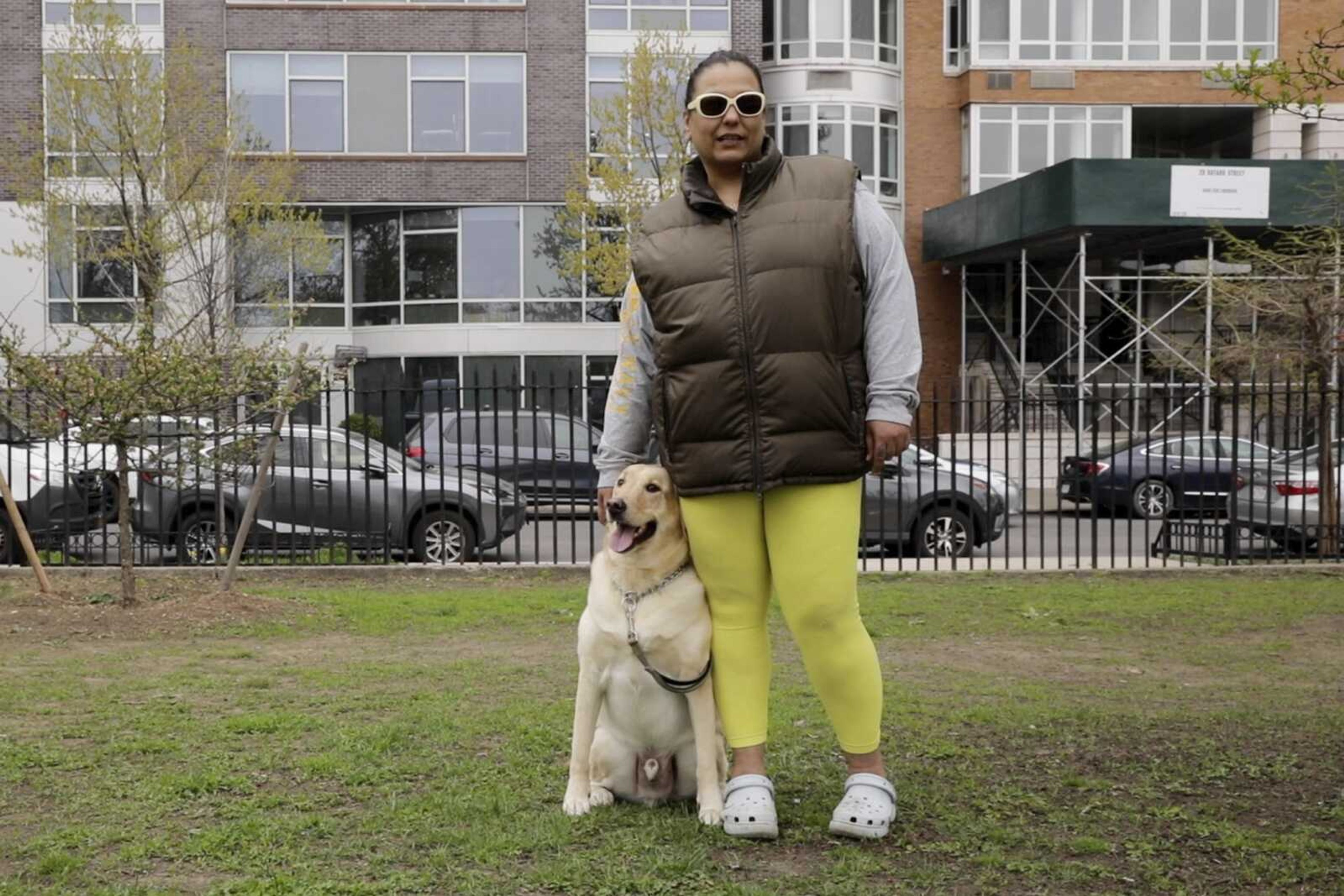 Suly Ortiz stands with her yellow Labrador retriever, Ruben, on Tuesday at McCarren Park in the Brooklyn borough of New York.