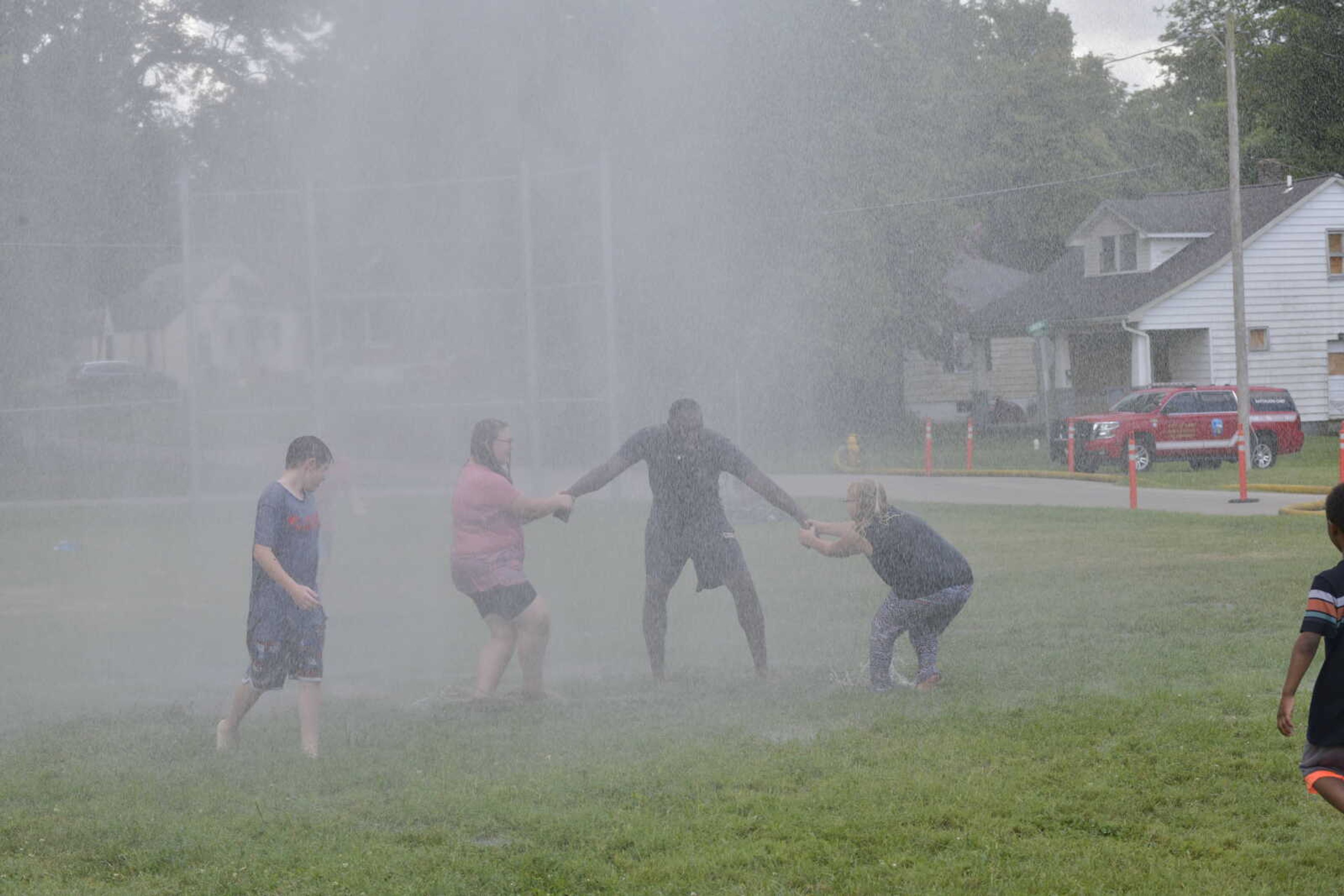 Cape Girardeau firefighter Marcus Johnson plays in the water with the kids who attended the department's fire Firefighter Friday.