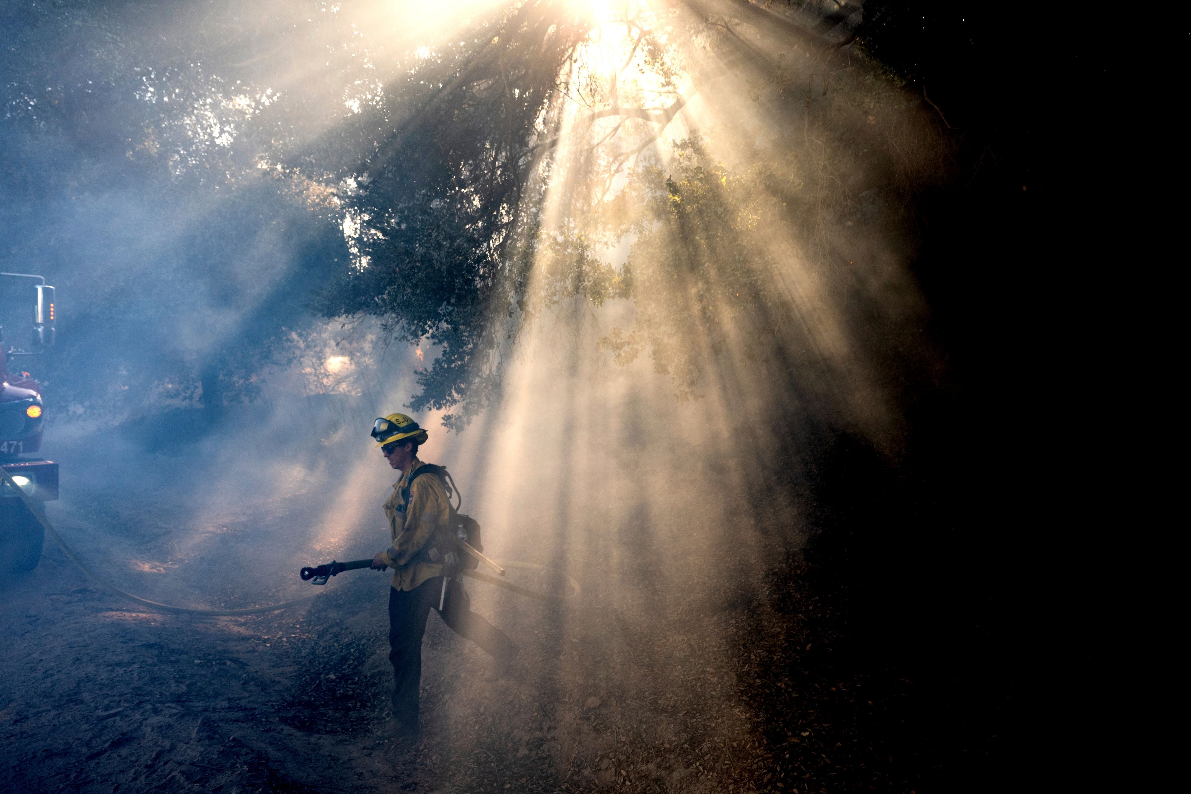 A firefighter walks through smoke while battling the Mountain Fire, Nov. 7, 2024, in Santa Paula, Calif. (AP Photo/Noah Berger)