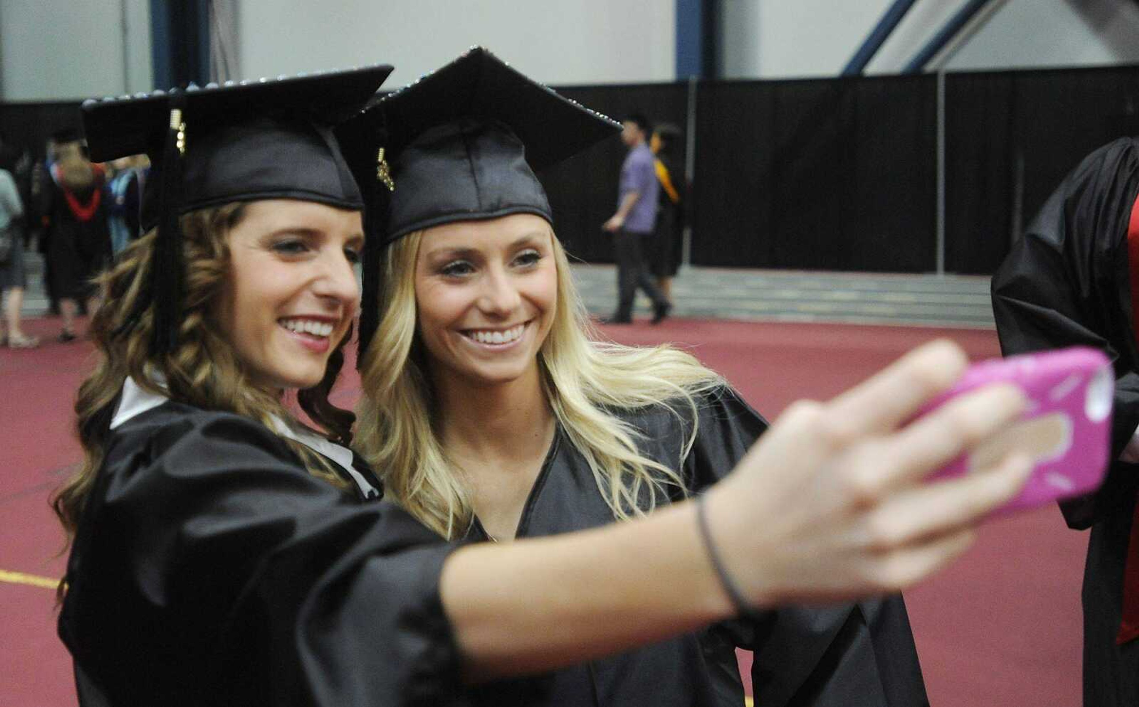 Southeast Missouri State University graduates Natalie Hahn, left, and Laura Spotanski get a picture together before the 2013 Spring Commencement ceremony Saturday at the Show Me Center. (ADAM VOGLER)