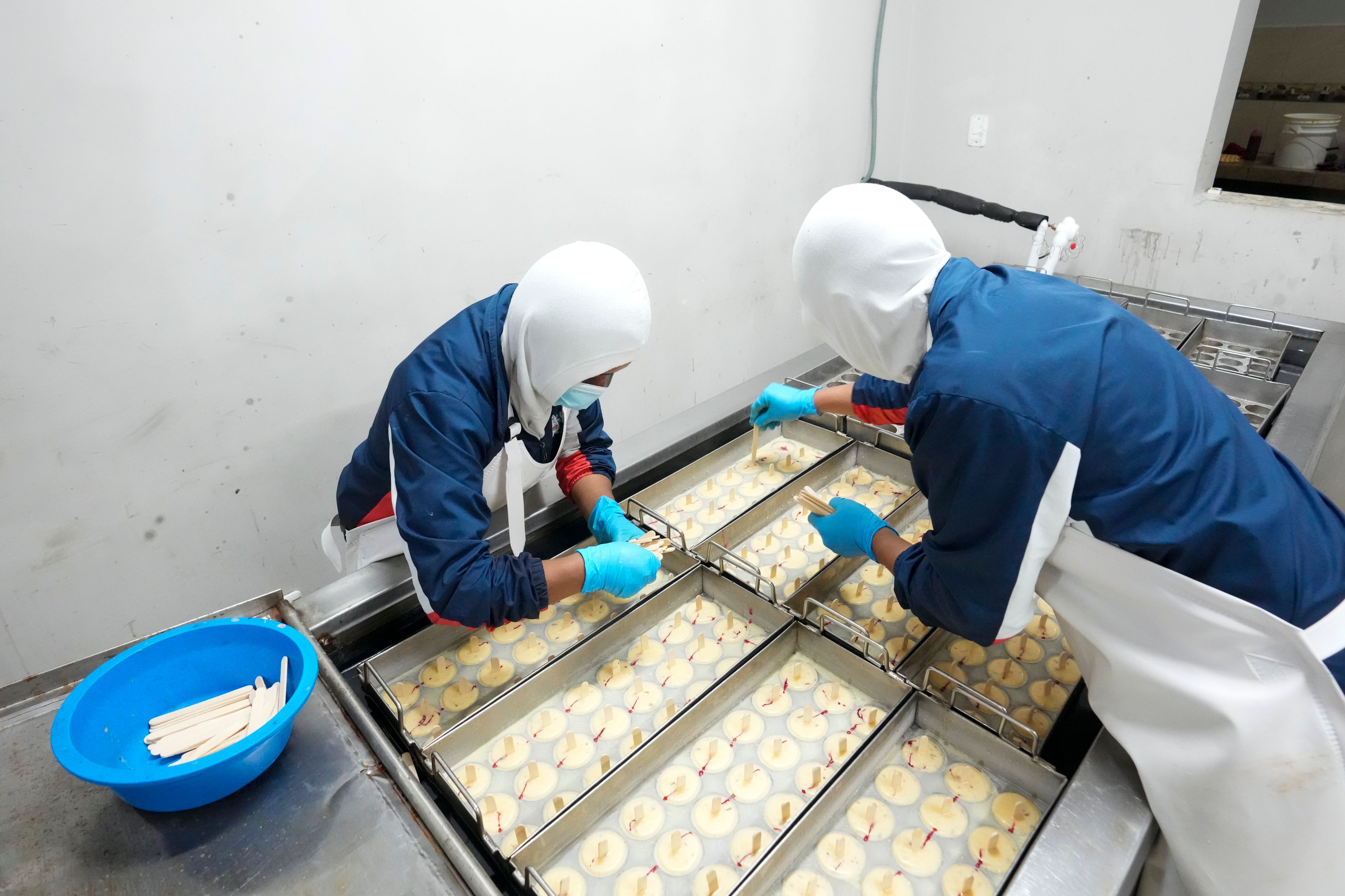 Workers prepare popsicles at an artisanal factory in Salcedo, Ecuador, Thursday, Nov. 28, 2024, amid a wave of power outages, triggered by a prolonged dry spell. (AP Photo/Dolores Ochoa)