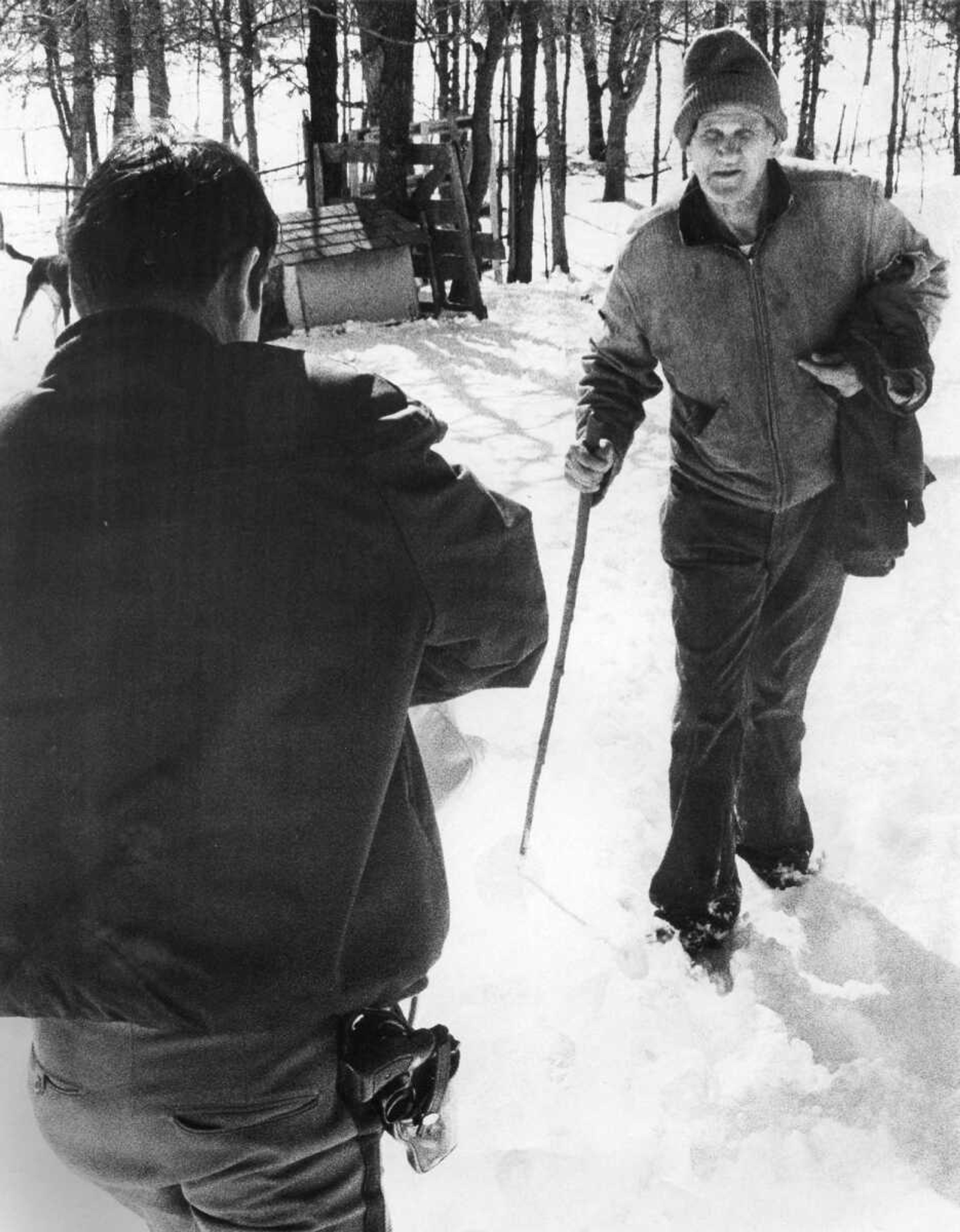 Perry County Deputy Bob McAte approached Sam Morse of rural Perryville, Missouri, with medication Morse needed. It was one of many such medical missions conducted by authorities and National Guard personnel in Southeast Missouri. (Southeast Missourian archive photo by Fred Lynch)