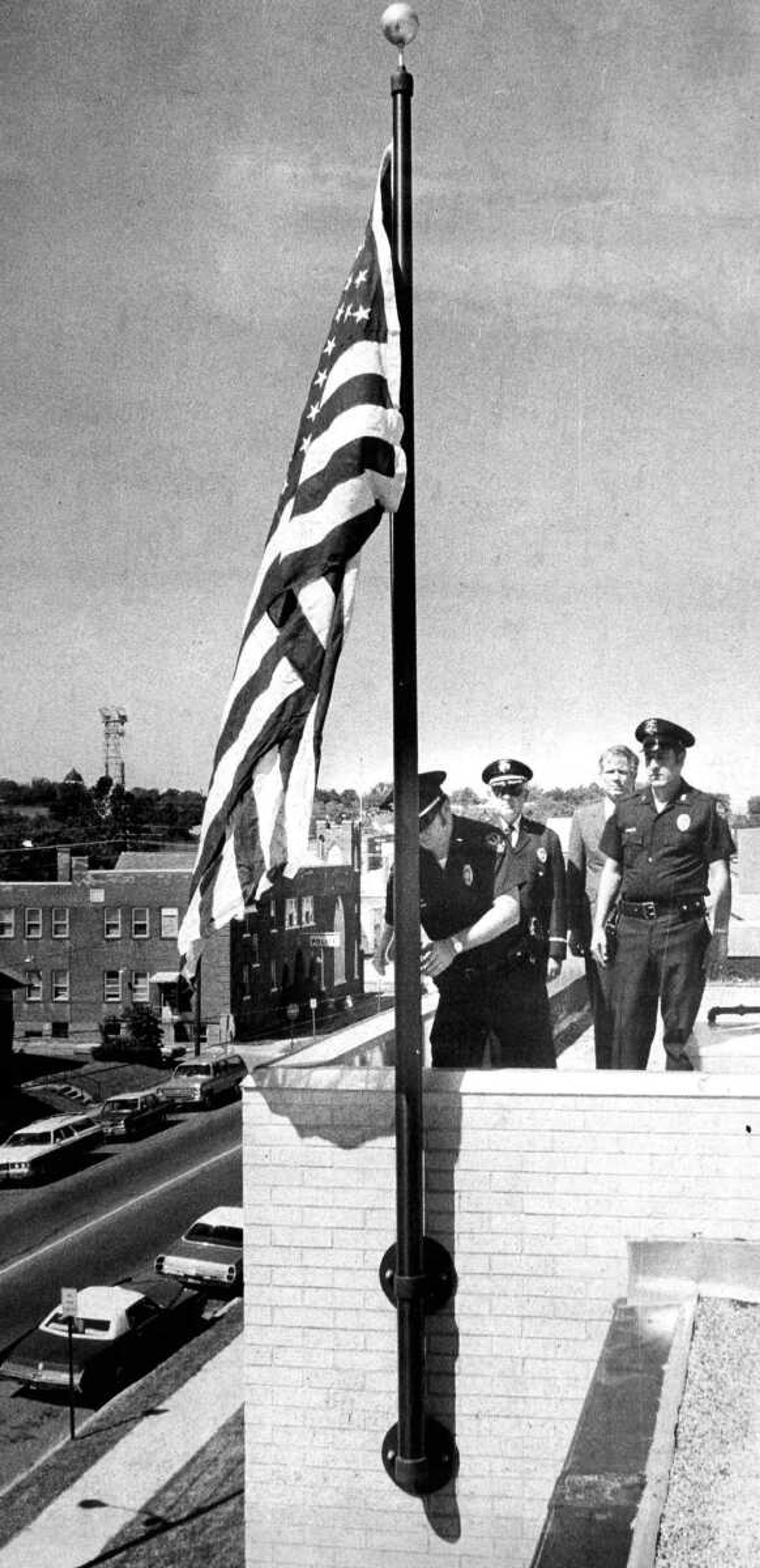 SOUTHEAST MISSOURIAN ~ photos@semissourian.com
Sept. 7, 1976
Lt. Howard Boyd Jr. raises the flag given to the city that was flown on the state Capitol. Watching Lt. Boyd are Chief Henry H. Gerecke, Rep. Burlison and Reserve Stg. Ed Williams.