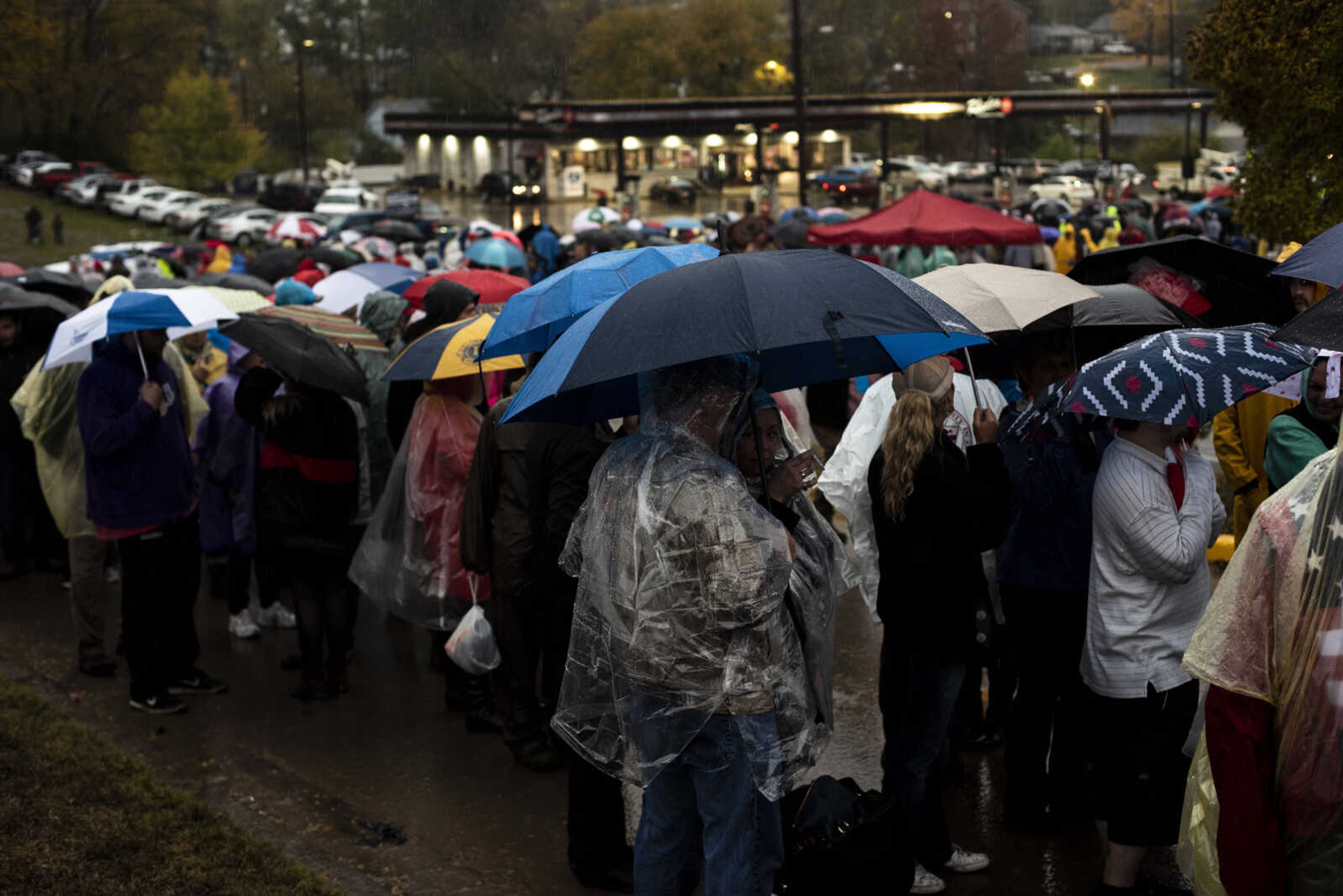 Supporters of President Trump stand in line as rain pours down outside of the Show Me Center Monday, Nov. 5, 2018, in Cape Girardeau.