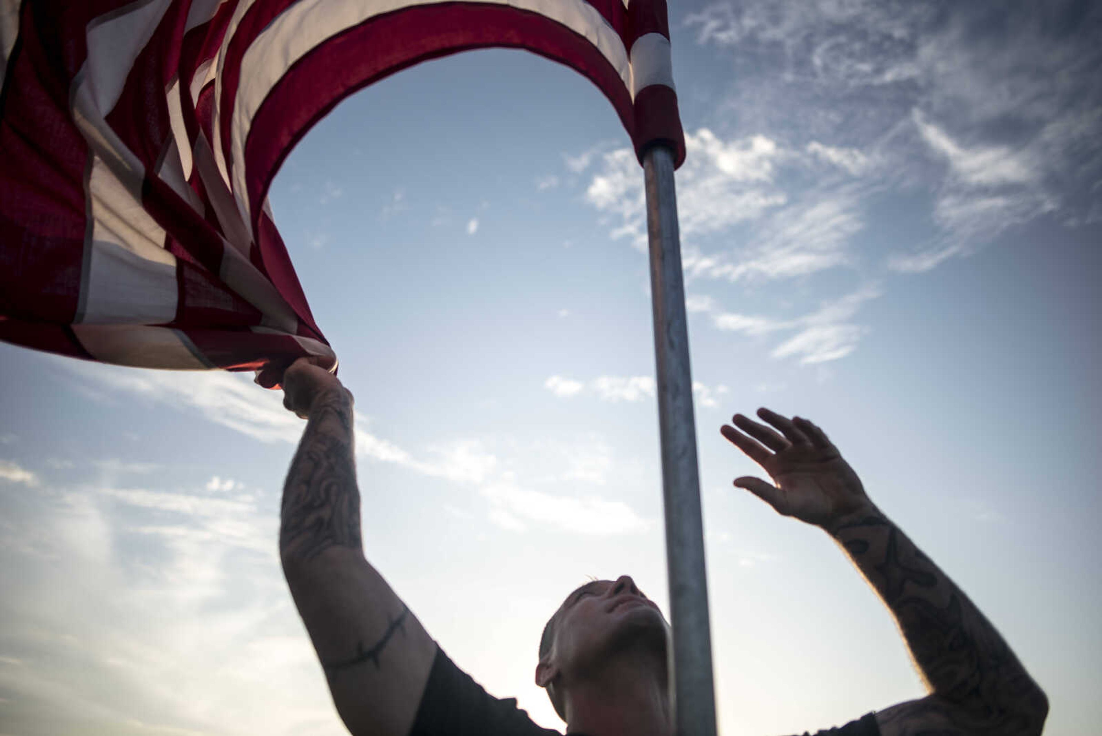 Volunteers install a flag Wednesday, July 3, 2019, Avenue of Flags in Cape Girardeau County Park.