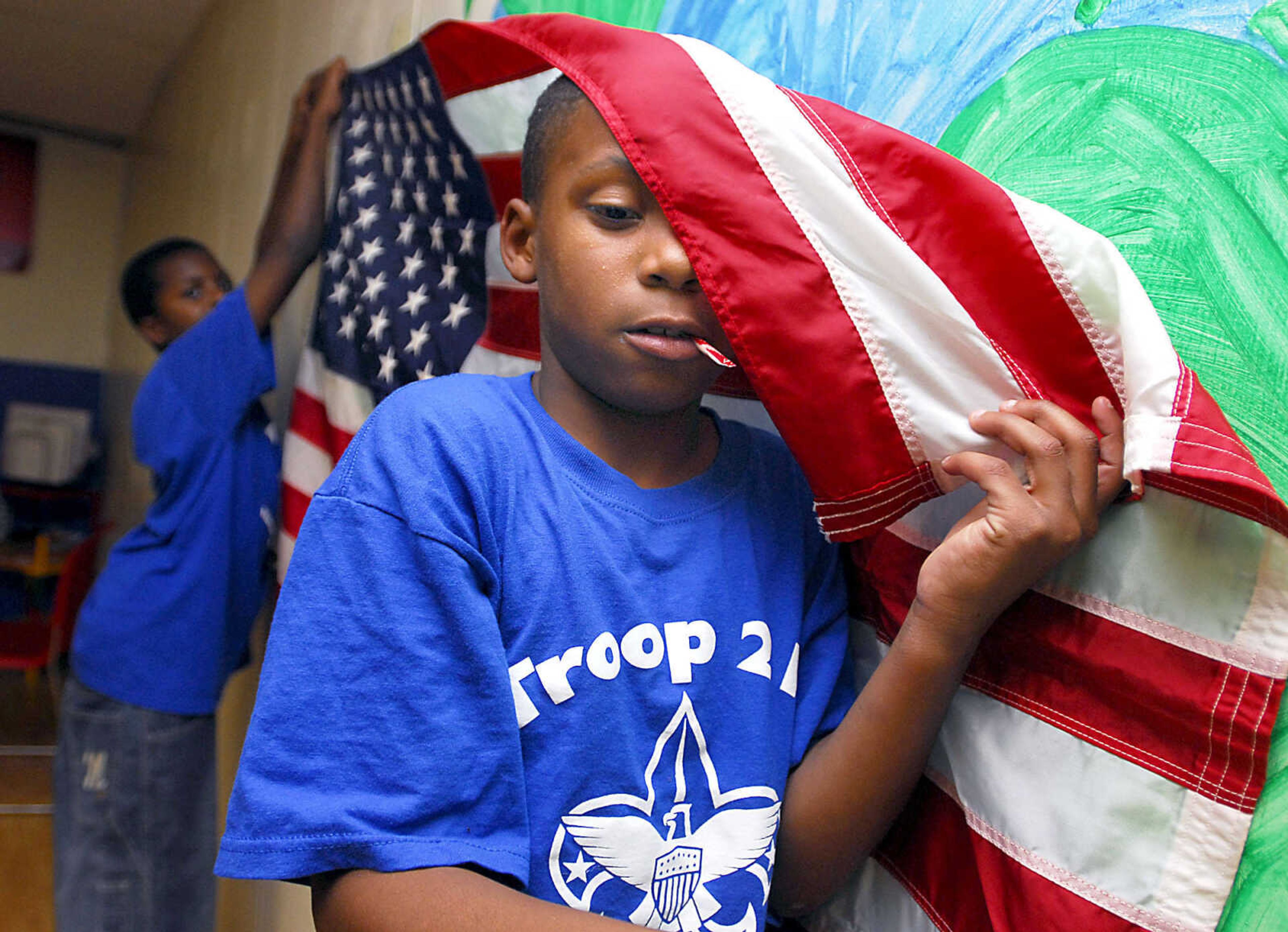 Scout Ivory Clark, 10, leans the American flag against the wall while searching for a pin to keep it in place before a Troop 215 meeting Tuesday evening, May 5, 2009, at the Cape Area Family Resource Center.