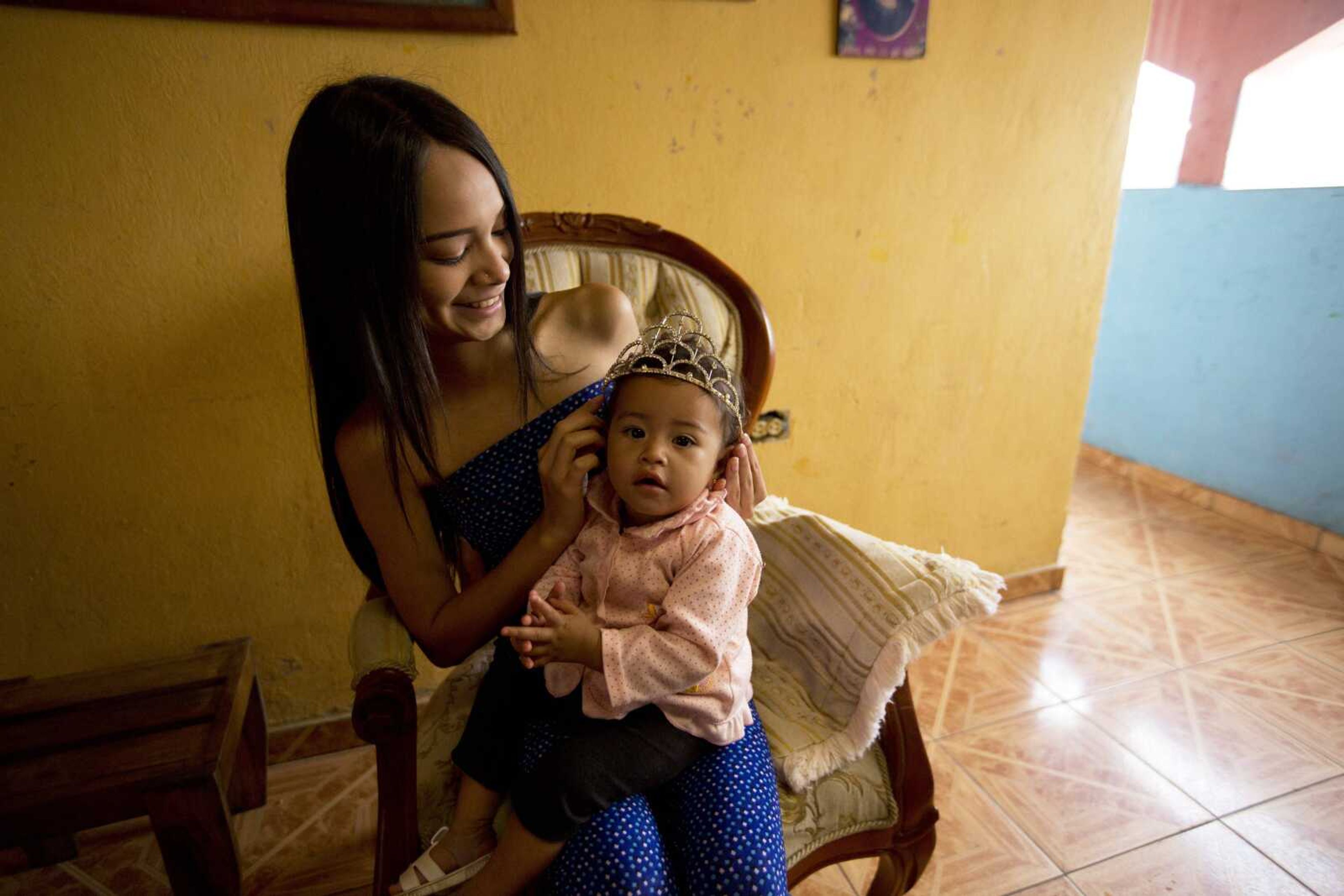 Johandrys Colls places a crown on her niece Victoria on July 1 at her home at a slum in the outskirts of Caracas, Venezuela.