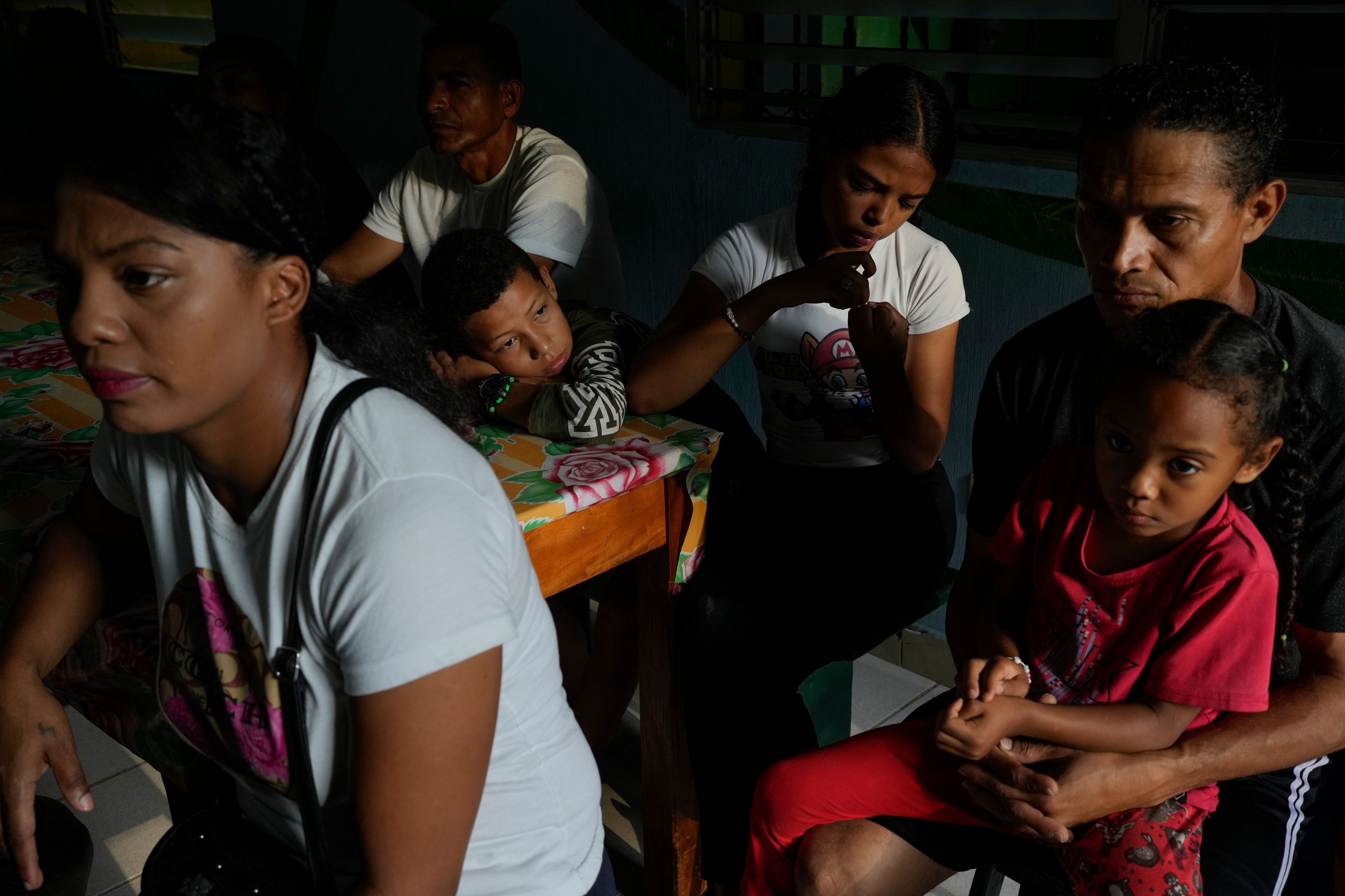 Colombian migrant Jon Hernandez holds his daughter as he waits for breakfast with his family at the Casa del Migrante shelter in Tecun Uman, Guatemala, Sunday, Oct. 27, 2024. (AP Photo/Matias Delacroix)