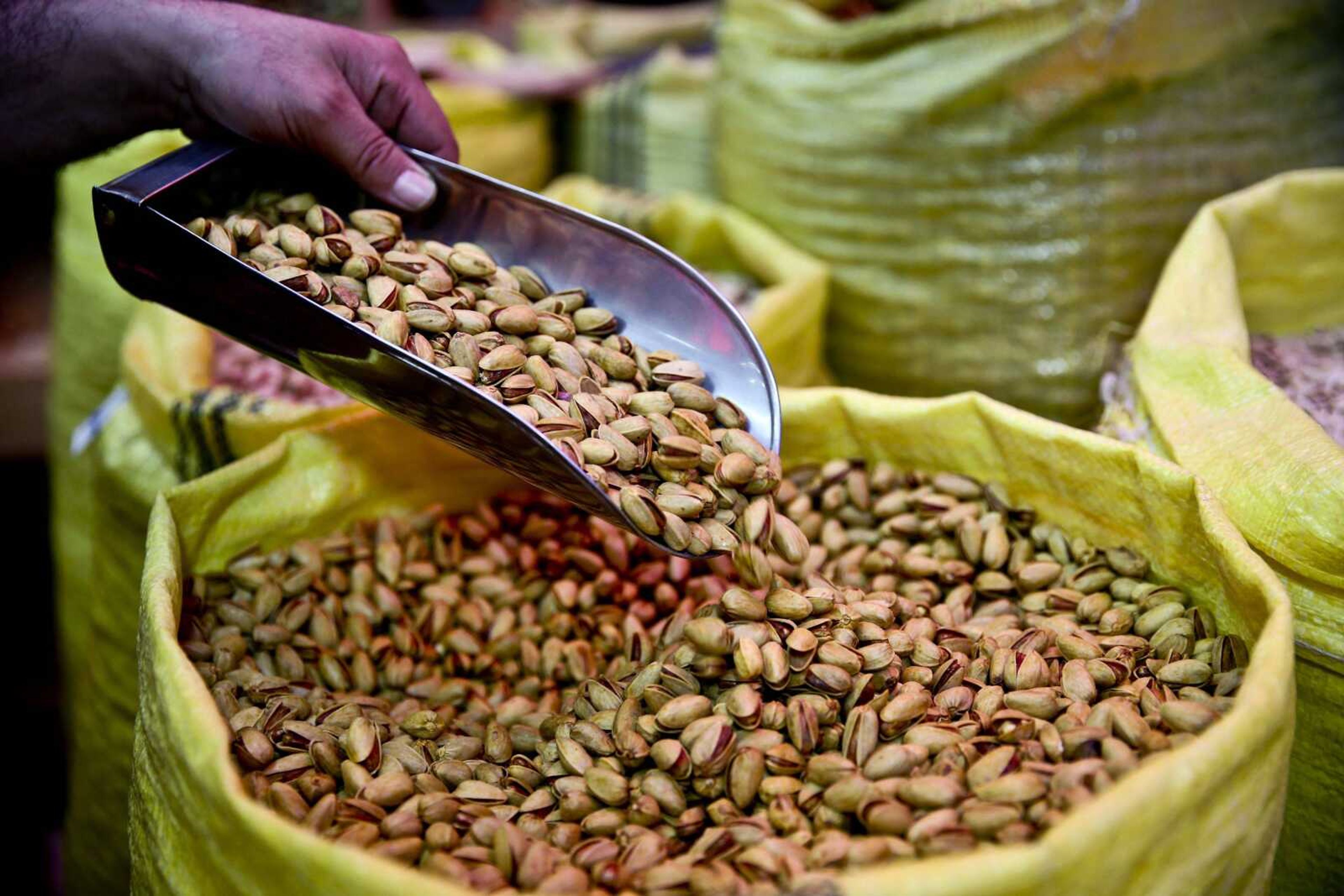 A shopkeeper sells pistachios at his shop March 31 in western Tehran, Iran. (Associated Press file)